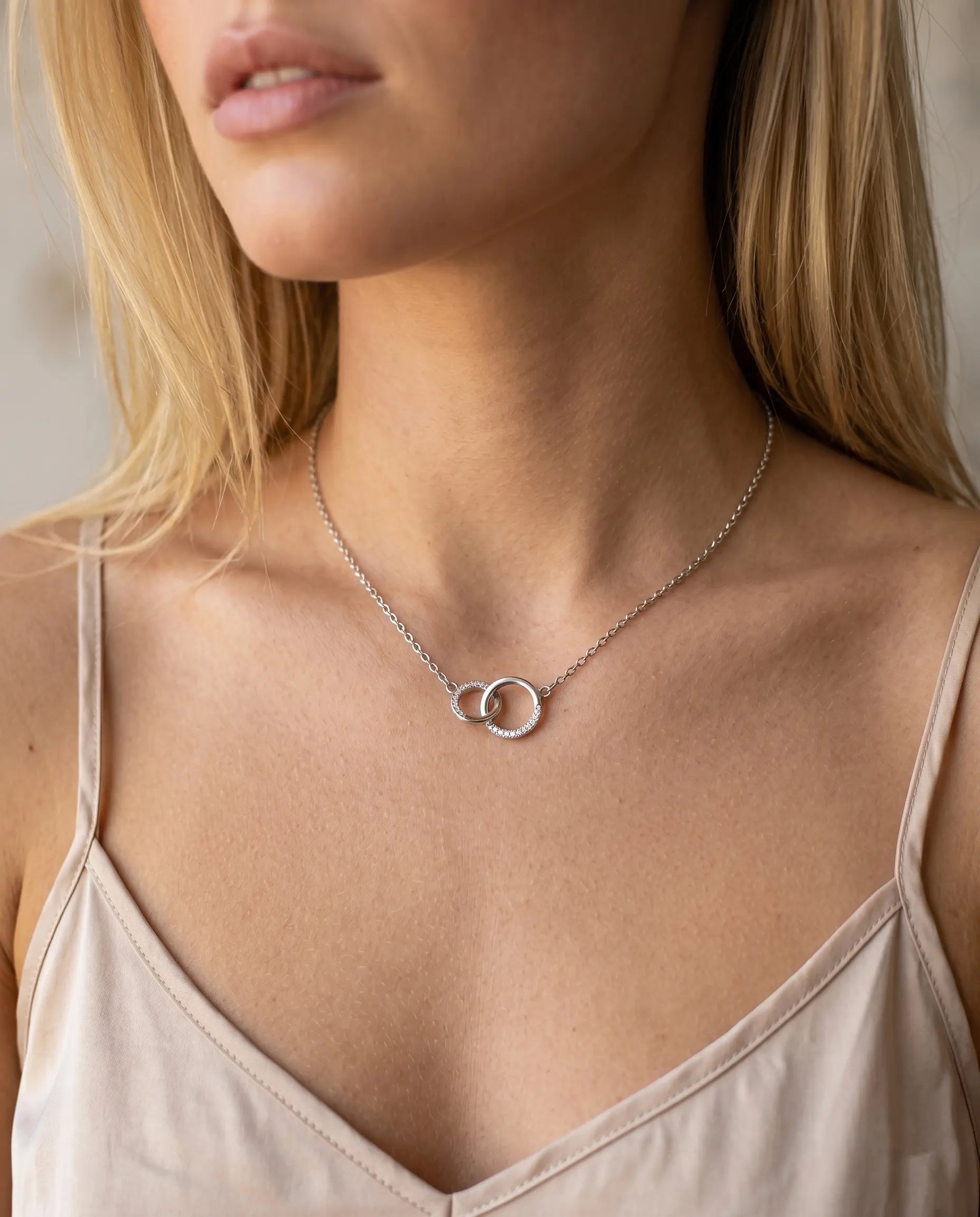 nuvia-interlocking-circles-necklace-gold-silver-925-luxury, symbolic-double-ring-pendant-connection-jewelry, premium-zirconia-detail-aesthetic, senya-jewelry-nuvia-collection