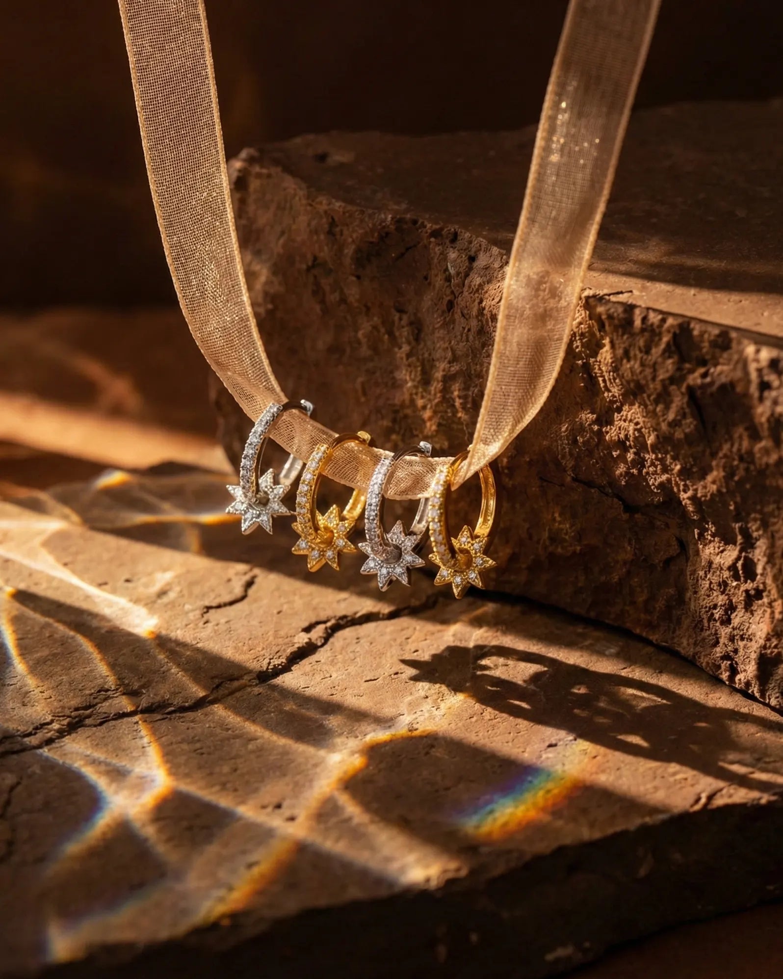 artistic-jewelry-display-sunlight-earrings-on-ribbon, creative-still-life-luxury-accessories-lighting, premium-fine-jewelry-showcase, modern-radiant-hoop-presentation