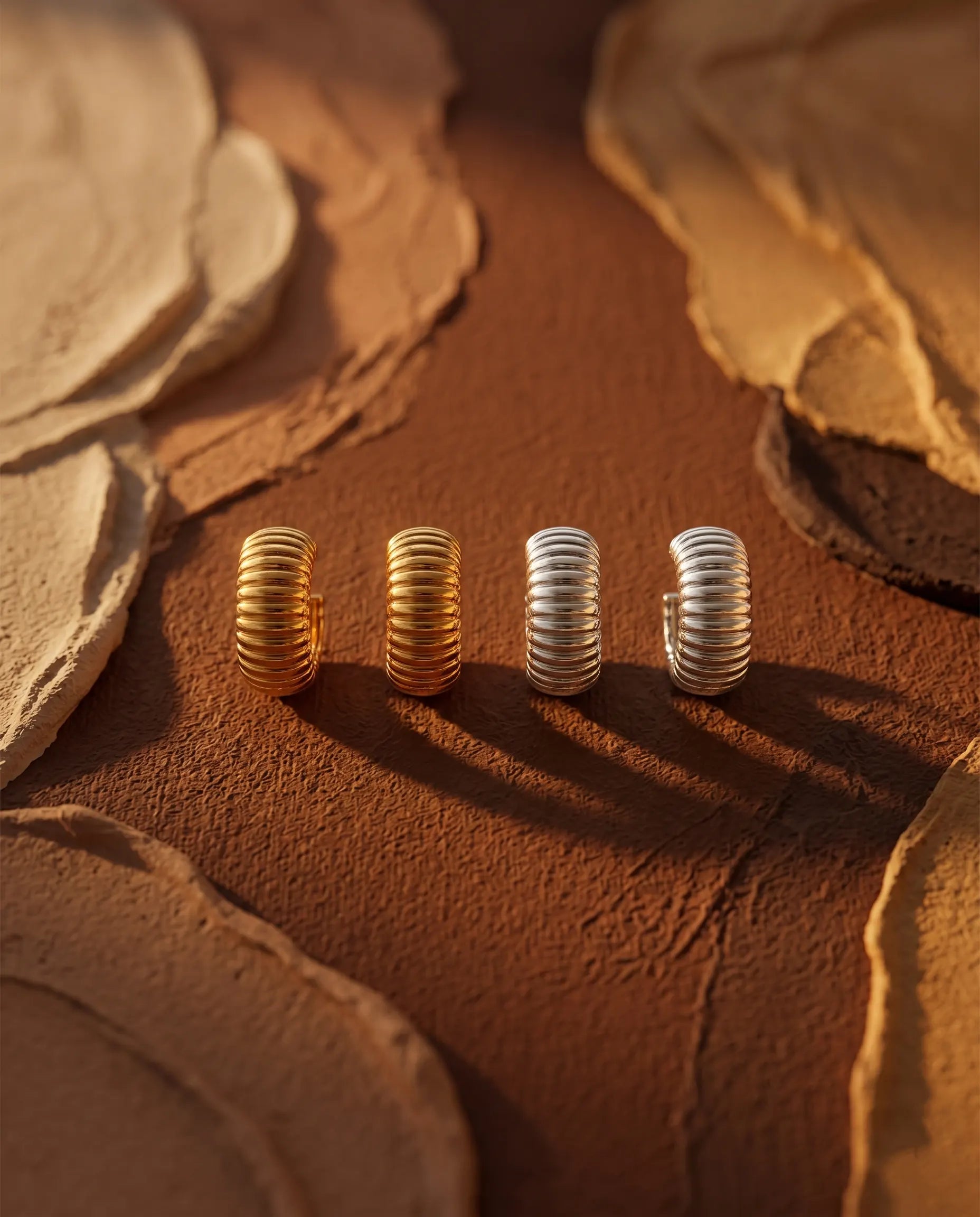 glam-ribbed-huggie-hoops-in-warm-natural-light-to-emphasize-the-rhythmic-surface-and-wide-band-design