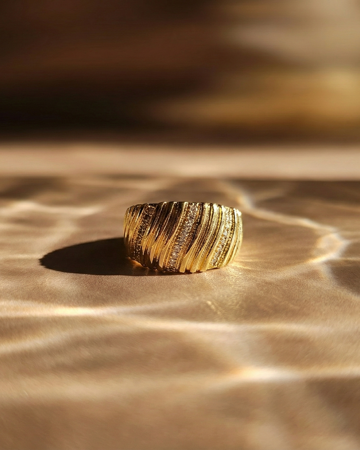 kenza-textured-gold-ring-on-natural-stone-highlighting-the-rhythmic-ribbed-surface-and-architectural-design