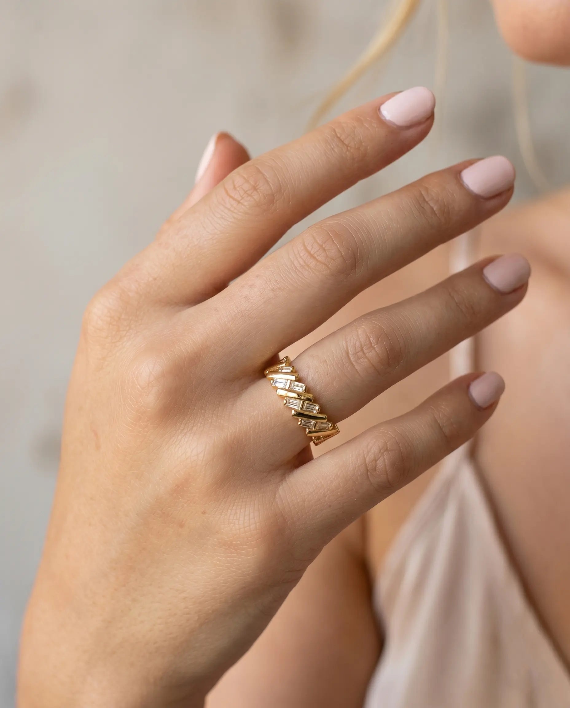model-wearing-gold-kaori-crossover-ring-lifestyle, elegant-modern-architectural-jewelry-on-hand, professional-women-luxury-accessories, chic-gold-eternity-band-styling, luxury-lifestyle-brand-model
