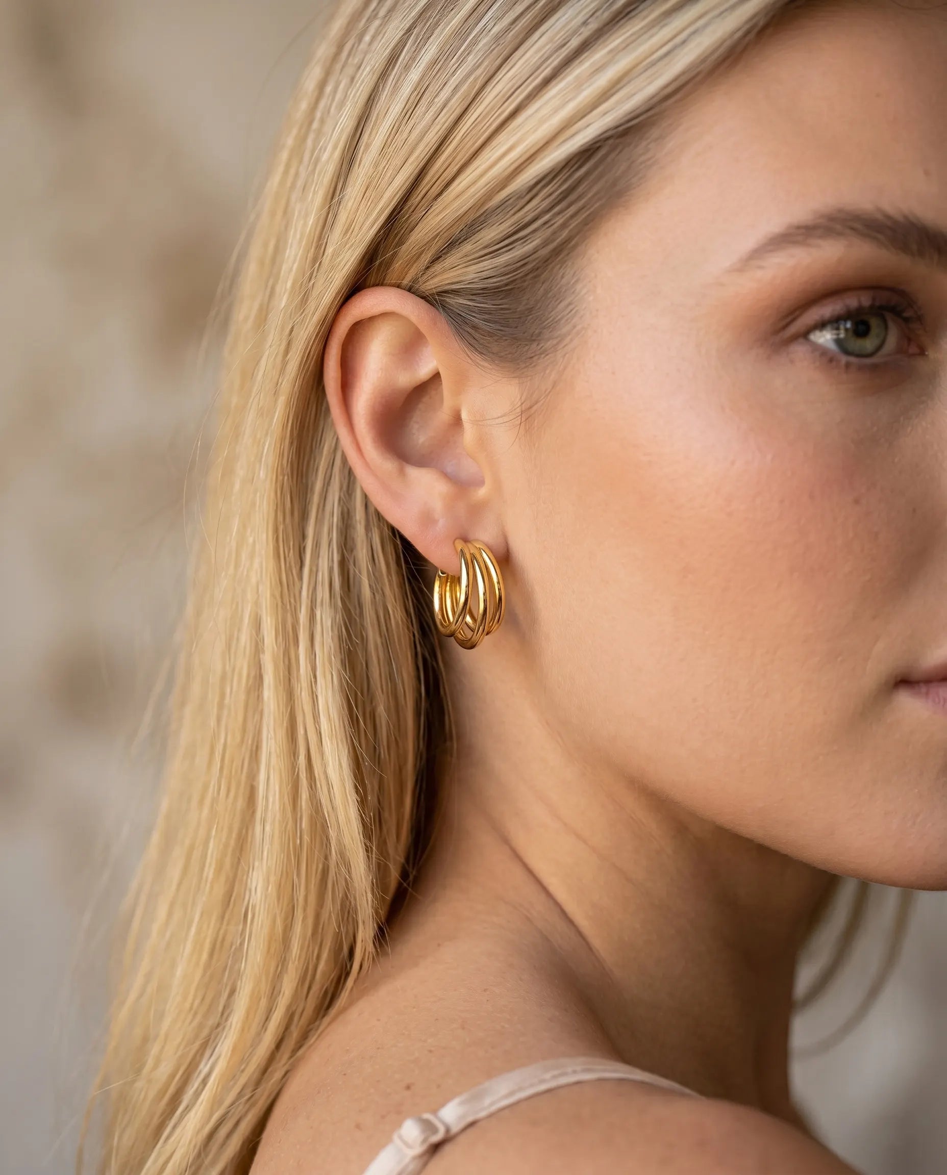 model-wearing-gold-lola-triple-layer-hoops-lifestyle, elegant-modern-feminine-jewelry-on-ear, professional-women-luxury-accessories, chic-multi-layered-gold-styling, luxury-lifestyle-brand-model