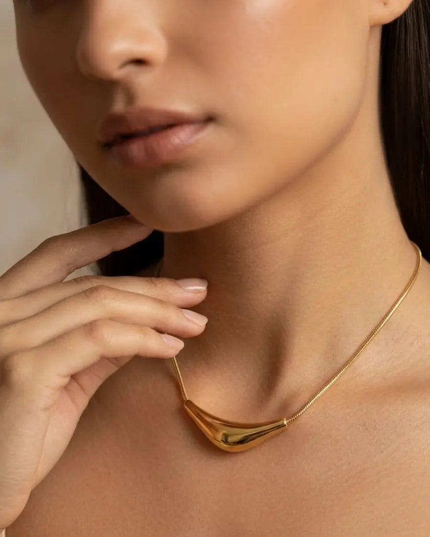 model-wearing-gold-prestige-arc-necklace-lifestyle, elegant-modern-feminine-jewelry-on-neck, professional-women-luxury-accessories, chic-gold-sculptural-pendant-styling, luxury-lifestyle-brand-model