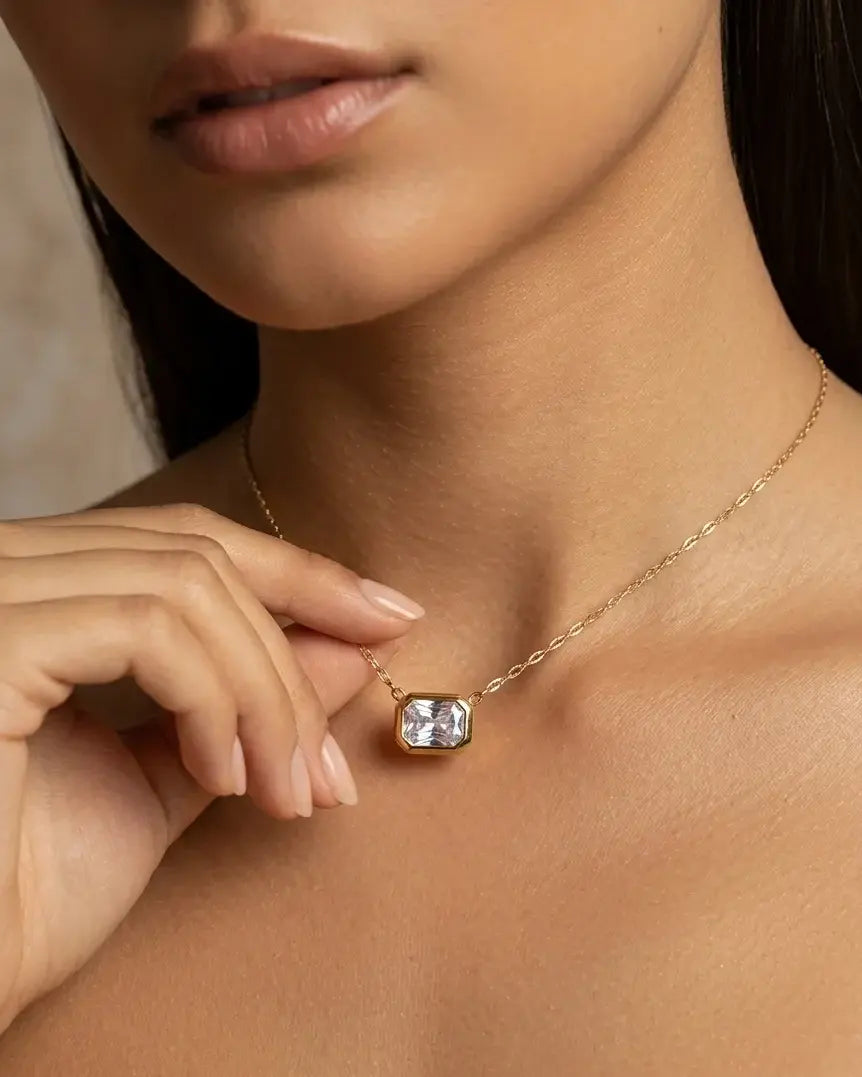 model-wearing-gold-quennie-emerald-cut-necklace-lifestyle, elegant-modern-feminine-jewelry-on-neck, professional-women-luxury-accessories, chic-geometric-solitaire-styling, luxury-lifestyle-brand-model