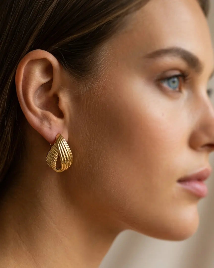 model-wearing-gold-rivera-chunky-hoops-lifestyle, elegant-modern-bold-jewelry-on-ear, professional-women-luxury-accessories, chic-gold-ribbed-hoop-styling, luxury-lifestyle-brand-model