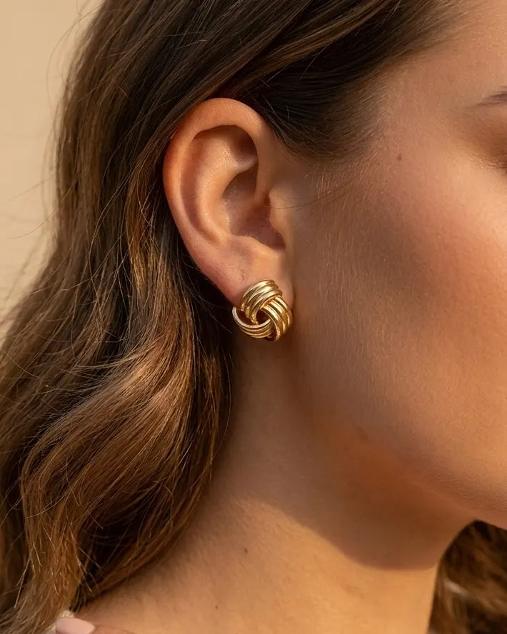 model-wearing-gold-samira-knot-earrings-lifestyle, elegant-modern-classic-jewelry-on-ear, professional-women-luxury-accessories, chic-gold-knot-stud-styling, luxury-lifestyle-brand-model