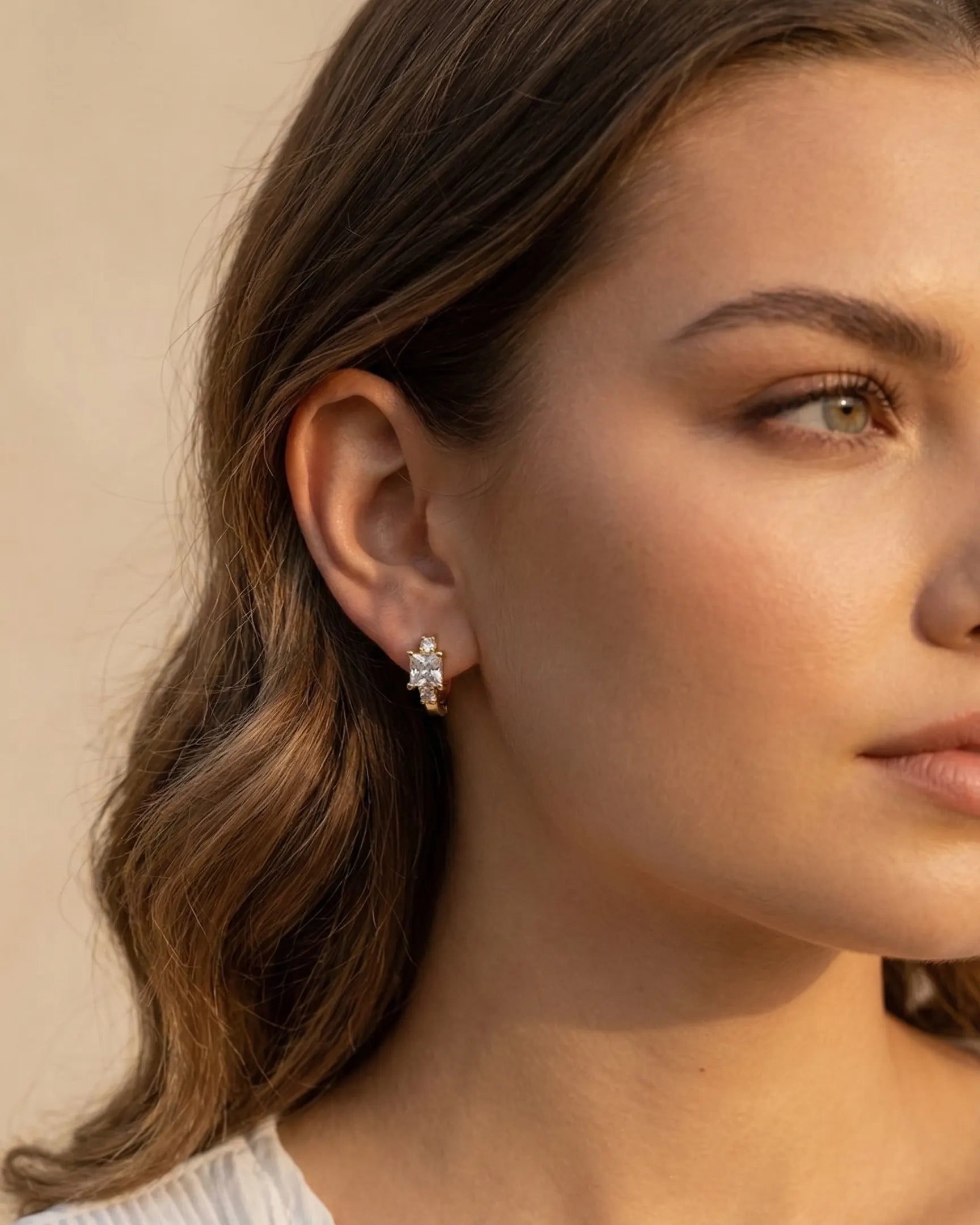 model-wearing-silver-cassie-geometric-huggies-on-ear, elegant-royal-feel-minimalist-jewelry-lifestyle, professional-women-luxury-accessories, chic-geometric-crystal-earring-photography, luxury-lifestyle-brand-model
