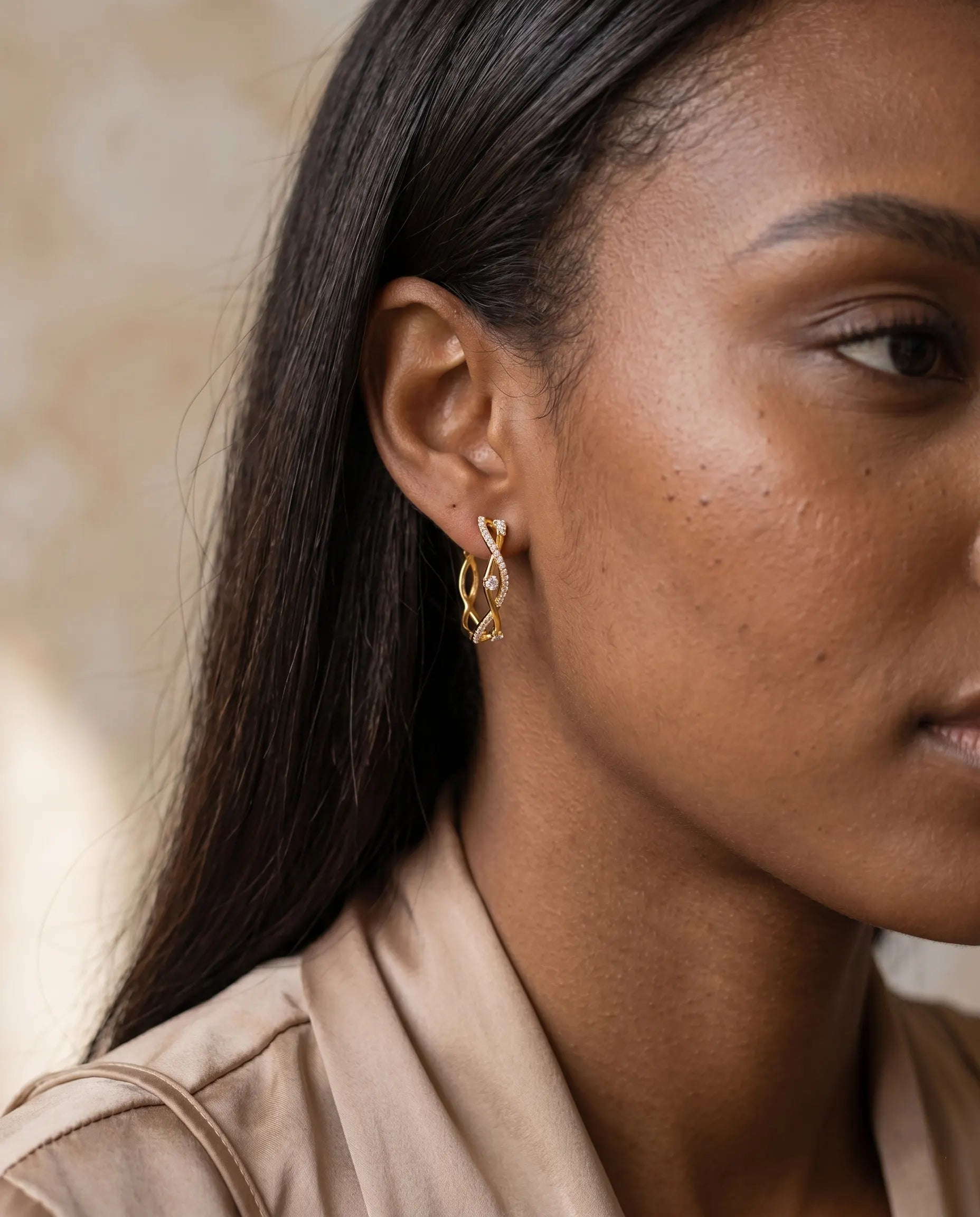model-wearing-silver-maddie-twisted-pave-hoops-lifestyle, elegant-modern-feminine-jewelry-on-ear, professional-women-luxury-accessories, chic-interlocking-silver-styling, luxury-lifestyle-brand-model