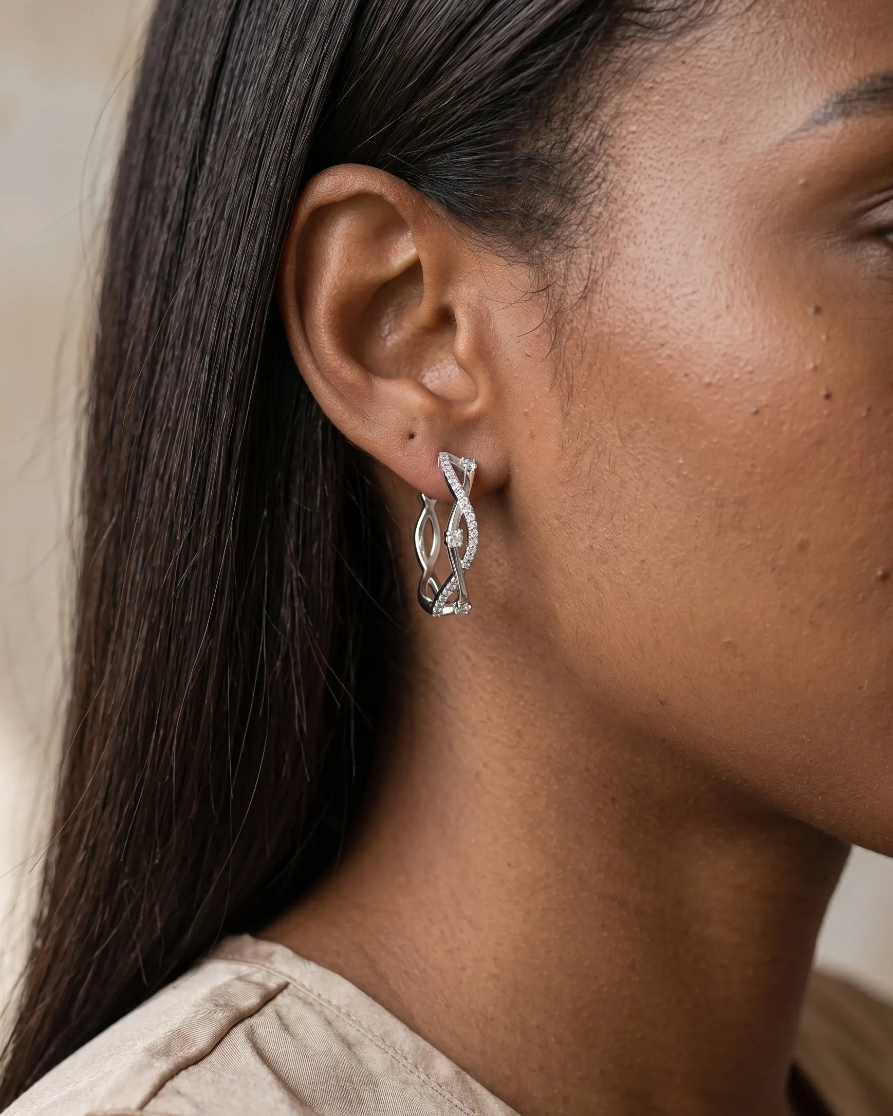 model-wearing-silver-maddie-twisted-pave-hoops-lifestyle, elegant-modern-feminine-jewelry-on-ear, professional-women-luxury-accessories, chic-interlocking-silver-styling, luxury-lifestyle-brand-model