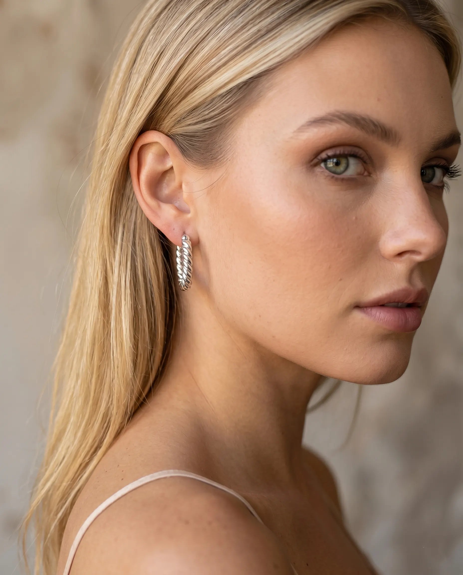 model-wearing-silver-mimi-beaded-huggie-earrings-lifestyle, elegant-modern-feminine-jewelry-on-ear, professional-women-luxury-accessories, chic-textured-silver-styling, luxury-lifestyle-brand-model