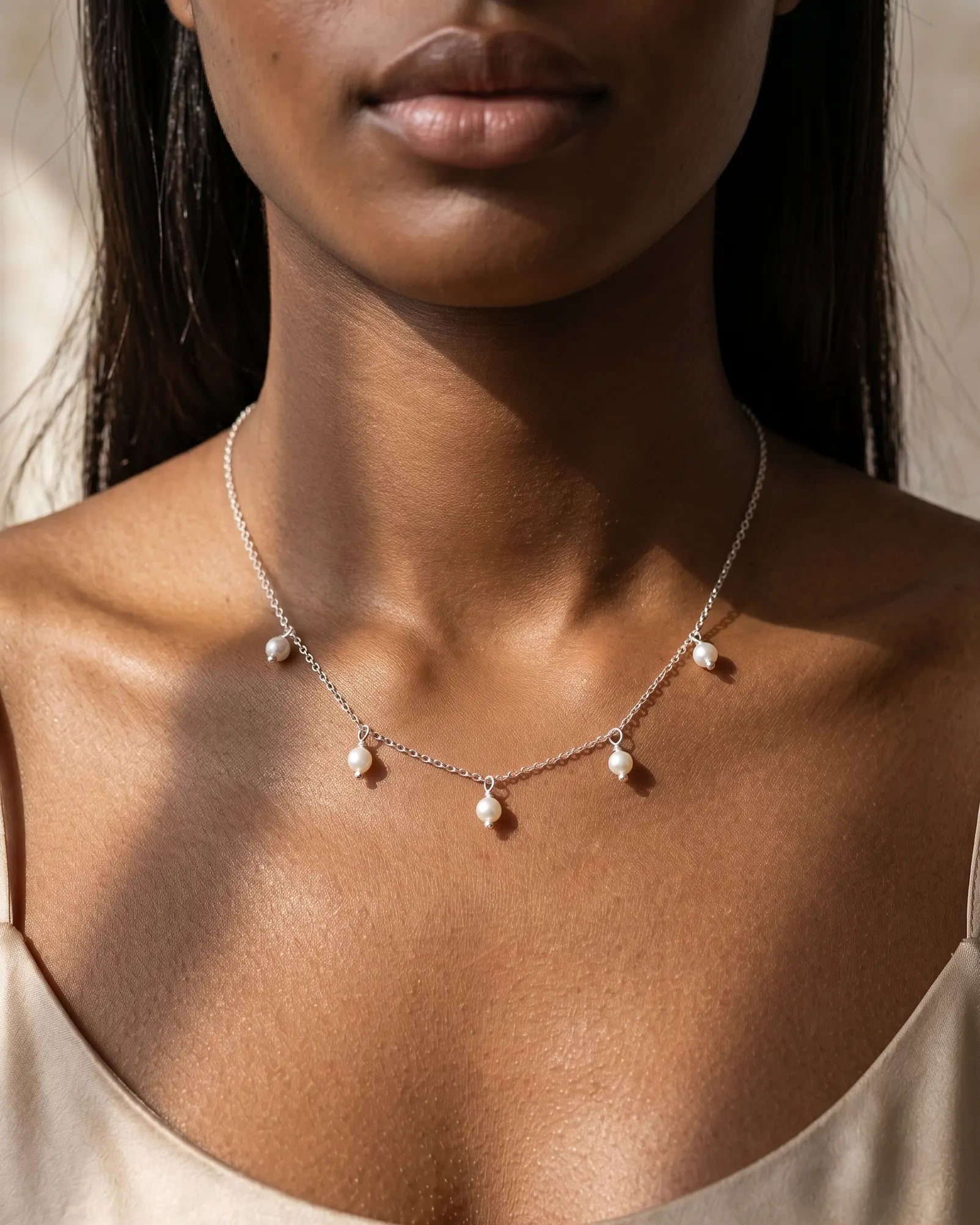 model-wearing-silver-nora-pearl-necklace-lifestyle, elegant-modern-feminine-jewelry-on-neck, professional-women-luxury-accessories, chic-multi-pearl-pendant-styling, luxury-lifestyle-brand-model