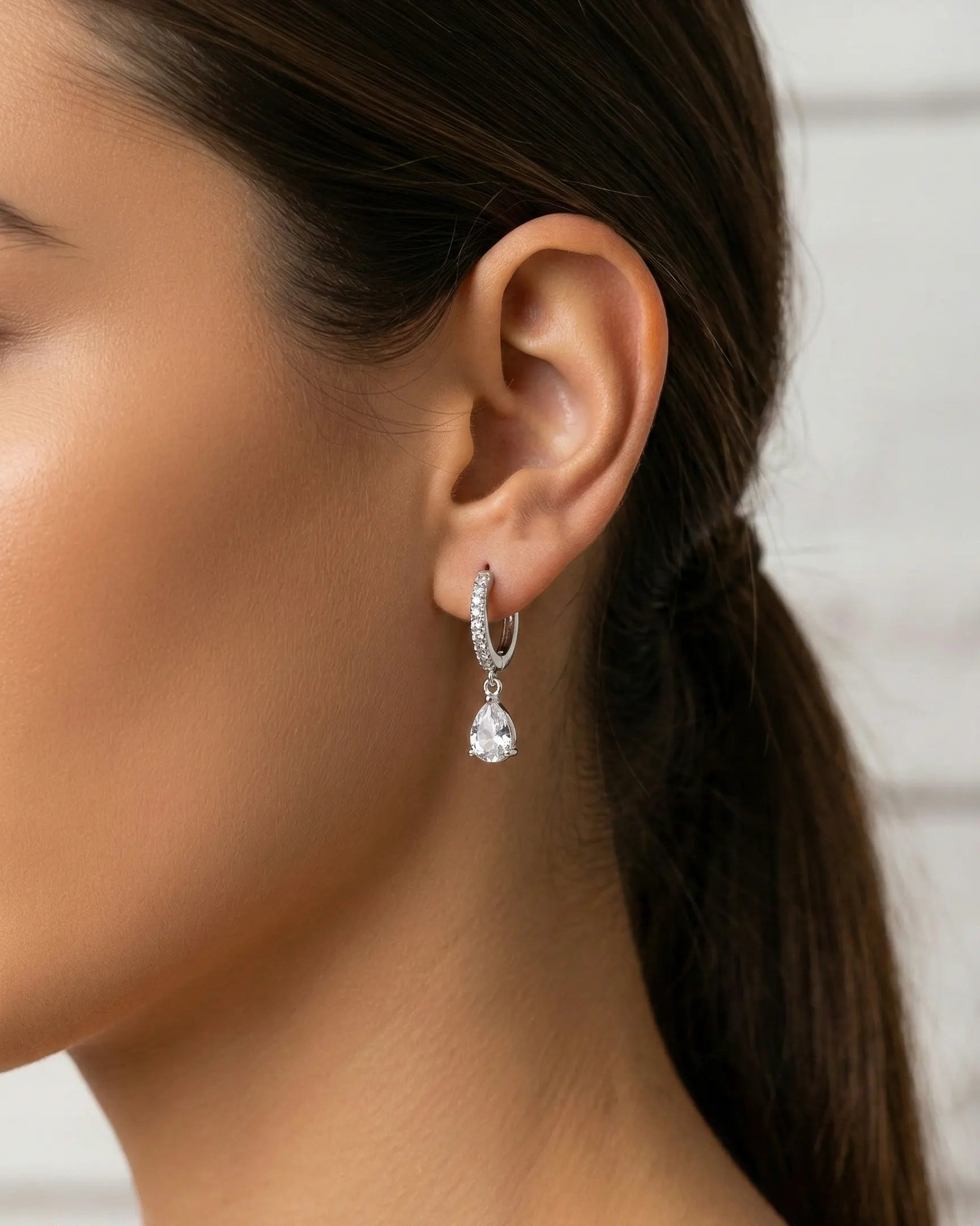 model-wearing-silver-quiola-teardrop-huggies, elegant-radiance-jewelry-lifestyle, professional-women-luxury-accessories, chic-minimalist-earring-photography, luxury-lifestyle-brand-model