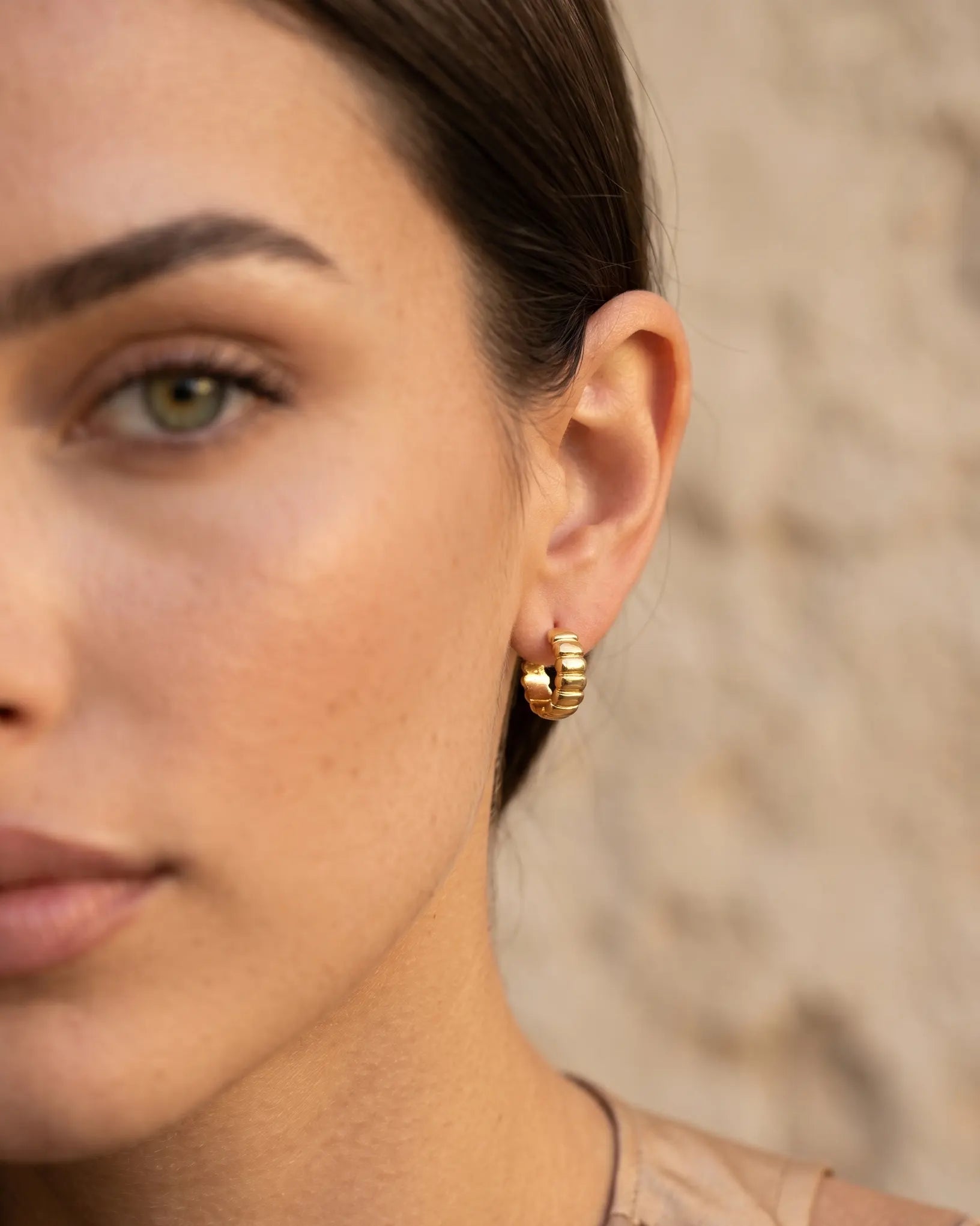 model-wearing-the-olvera-ribbed-huggie-hoops-showcasing-sophisticated-minimalist-ear-stacking-styling