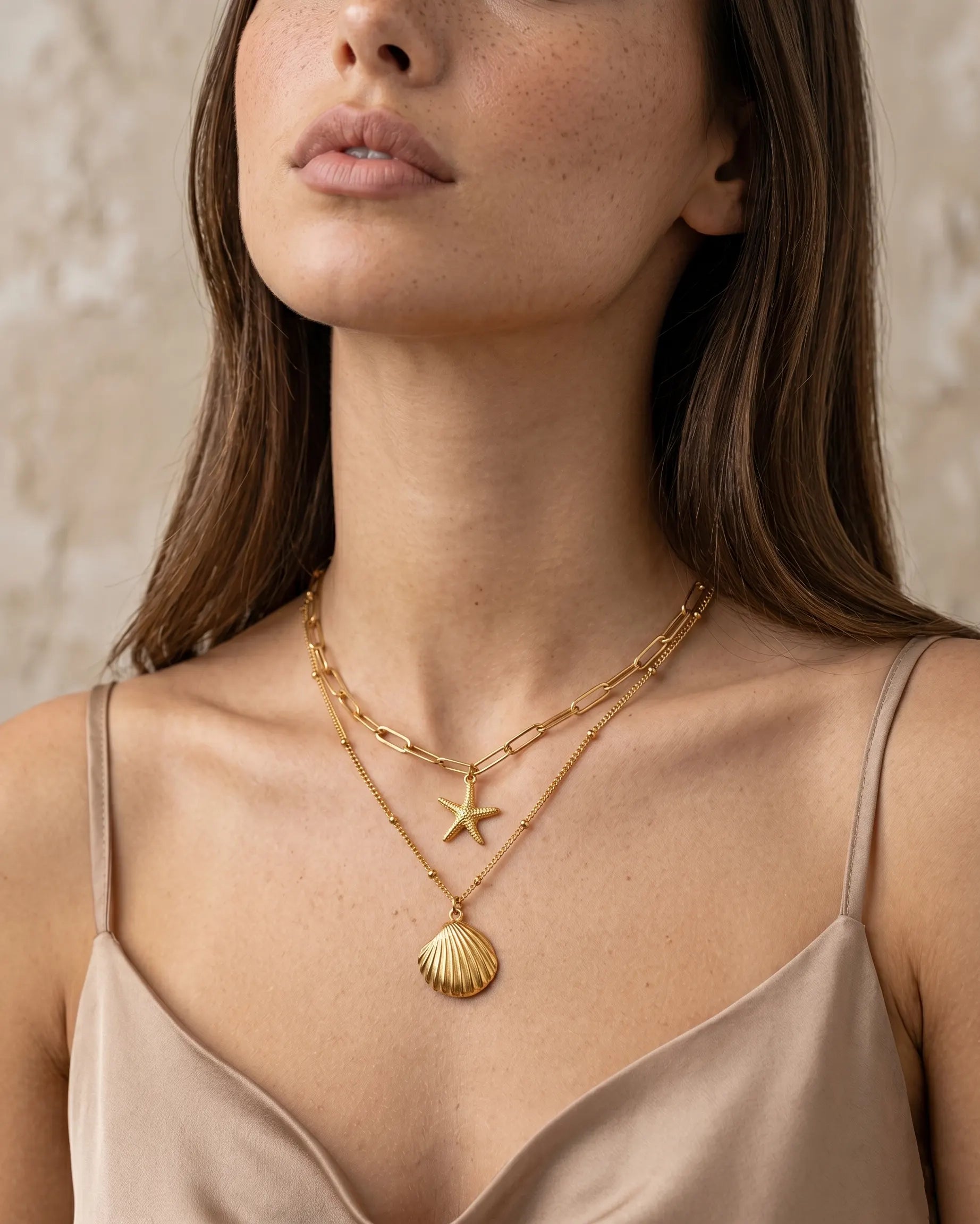 sunae-layered-gold-necklace-artfully-displayed-inside-a-large-seashell-minimalist-luxury-jewelry-photography-for-gifting