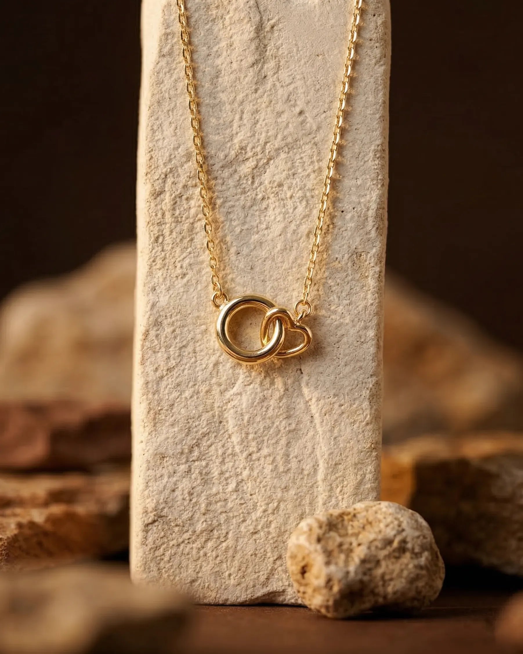 timeless-modern-aesthetic-interlocking-necklace-gold, 18k-gold-vermeil-finish-detail-valentina-pendant, gift-ideas-for-women-symbolic-jewelry, luxury-boutique-jewelry-netherlands, artistic-jewelry-flatlay-photography