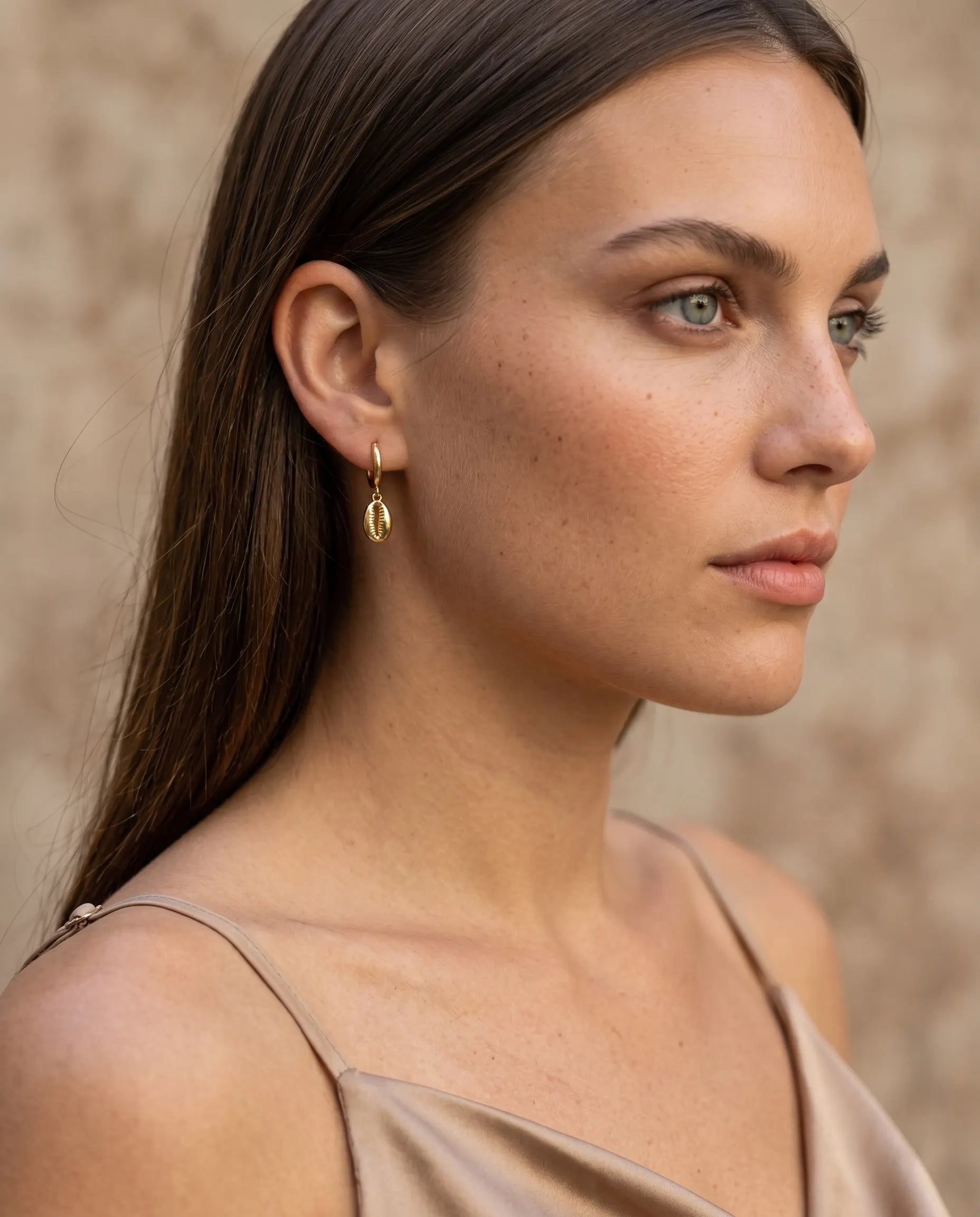 model-profile-wearing-sand-cowrie-shell-earrings-minimalist-everyday-luxury-jewelry-style-for-modern-women