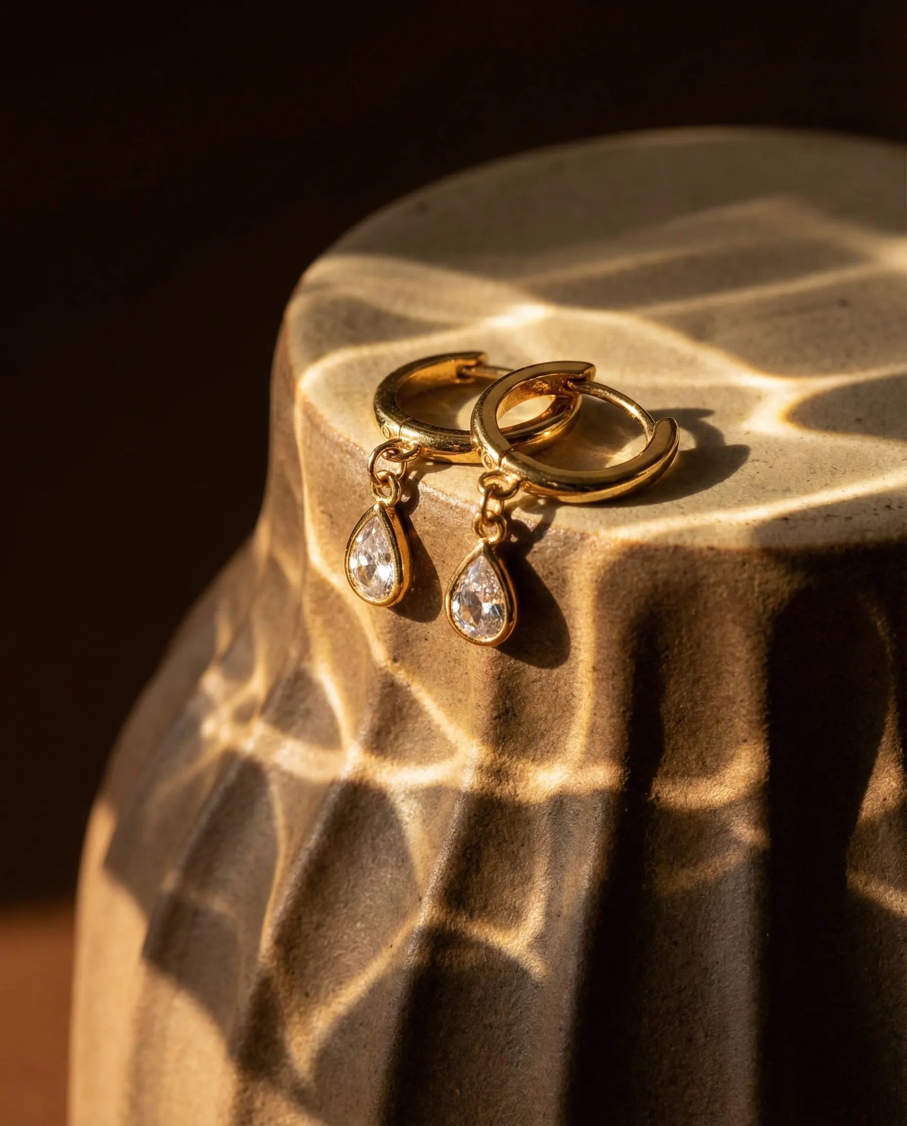 durable-tarnish-free-teardrop-huggies-gold, pear-cut-zirconia-earrings-texture, high-quality-18k-gold-plated-jewelry, anti-allergy-silver-hoops-premium, refined-jewelry-collection-germany, sustainable-luxury-jewelry-styling