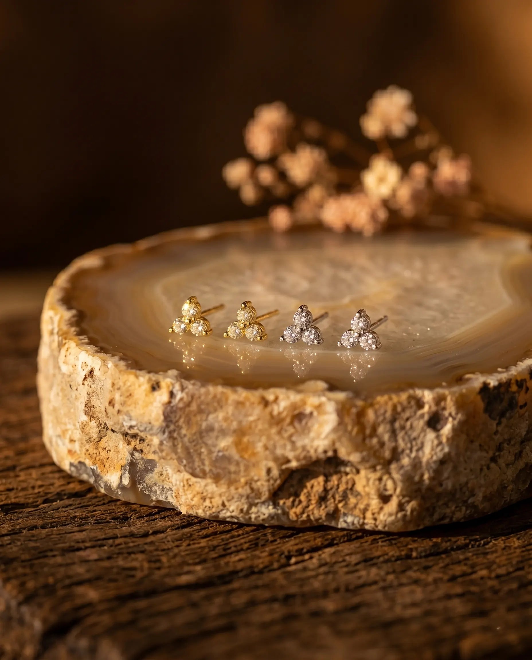artistic-jewelry-display-blossom-cluster-earrings-silver-gold, creative-still-life-luxury-accessories-lighting, premium-fine-jewelry-showcase, modern-radiant-stud-presentation