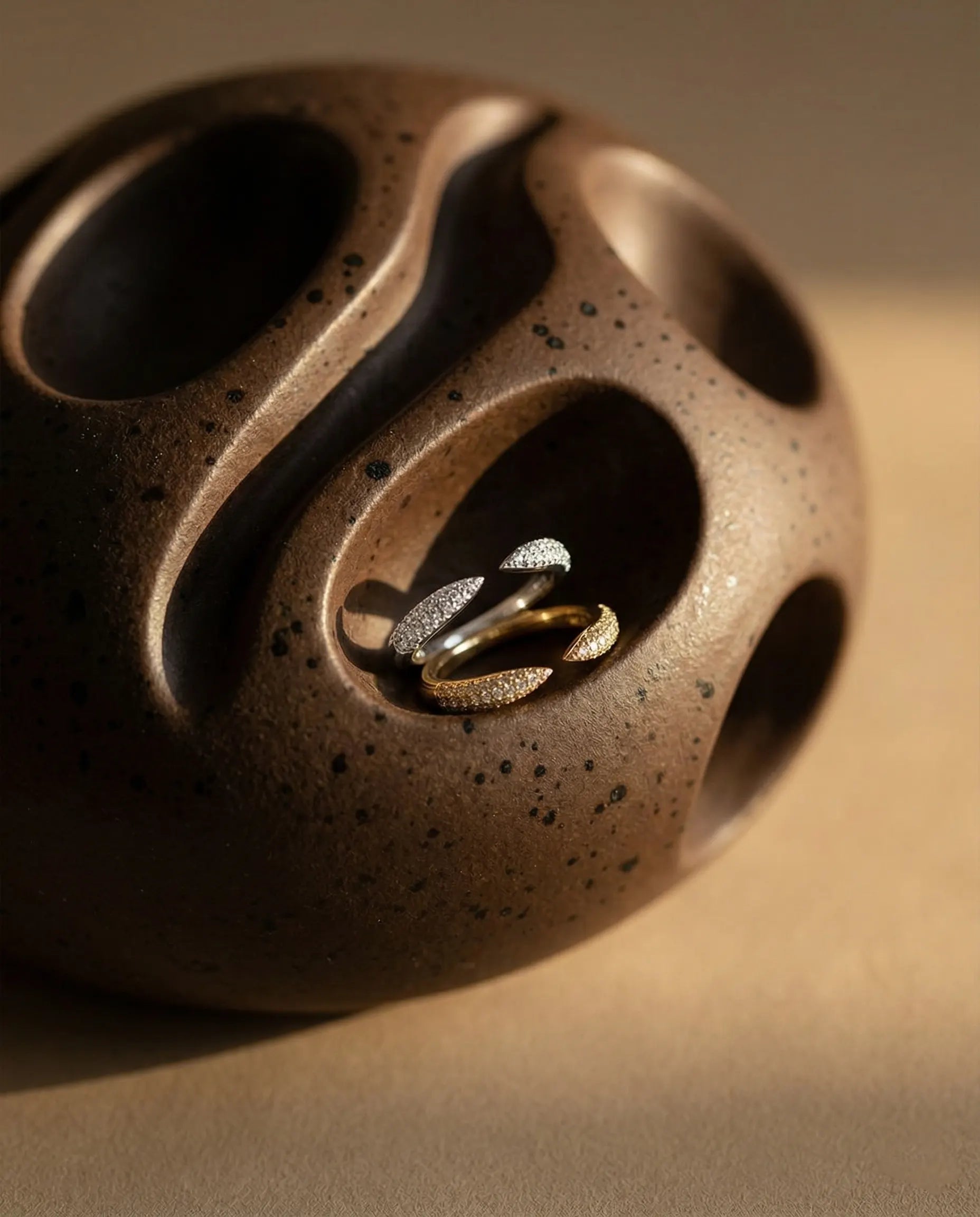 artistic-jewelry-display-tear-adjustable-ring-silver-gold, creative-still-life-luxury-accessories, premium-fine-jewelry-showcase, modern-sculptural-ring-presentation