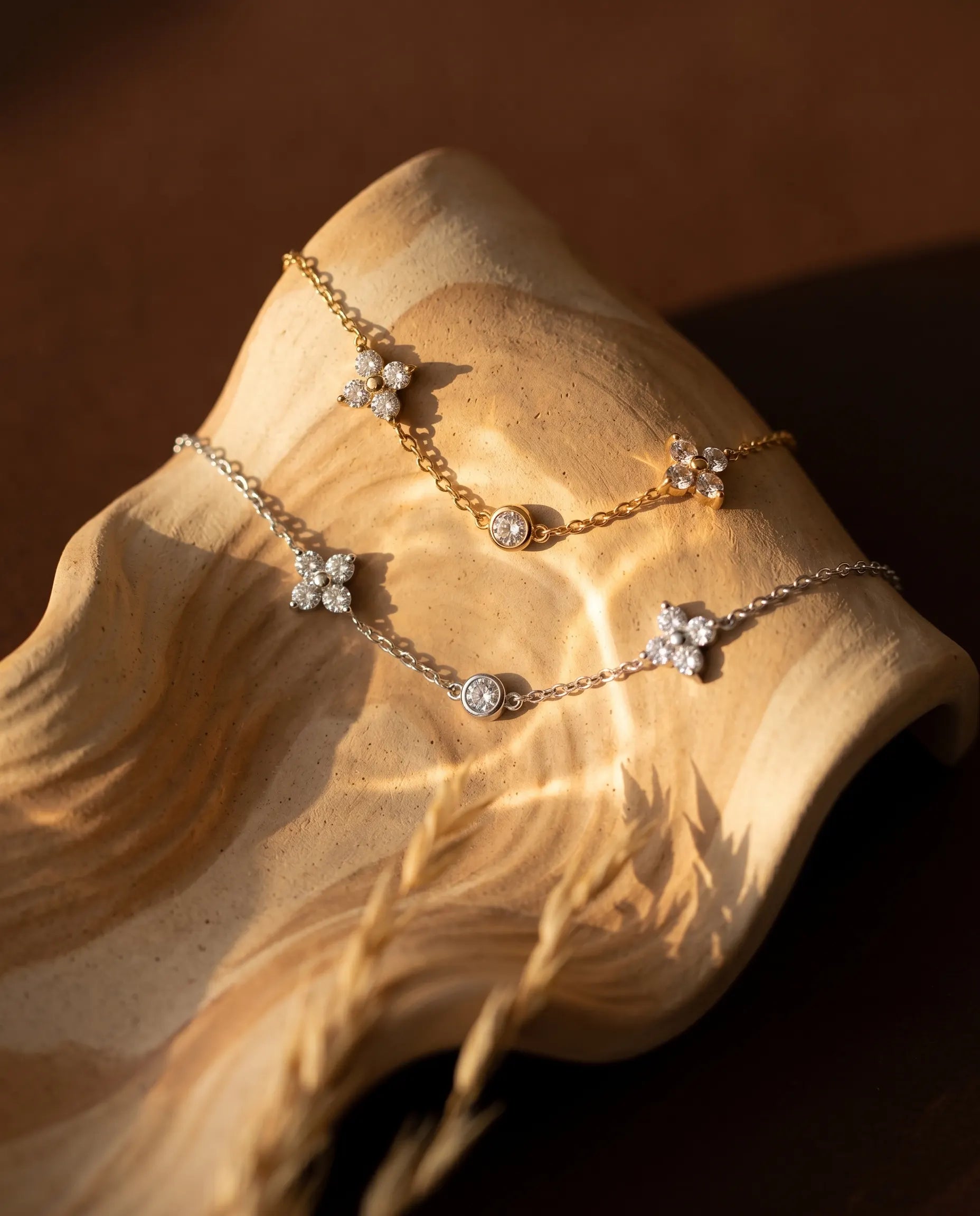 chloe-flower-station-bracelet-on-minimalist-white-sculptural-display-highlighting-gold-finish-and-design-detail