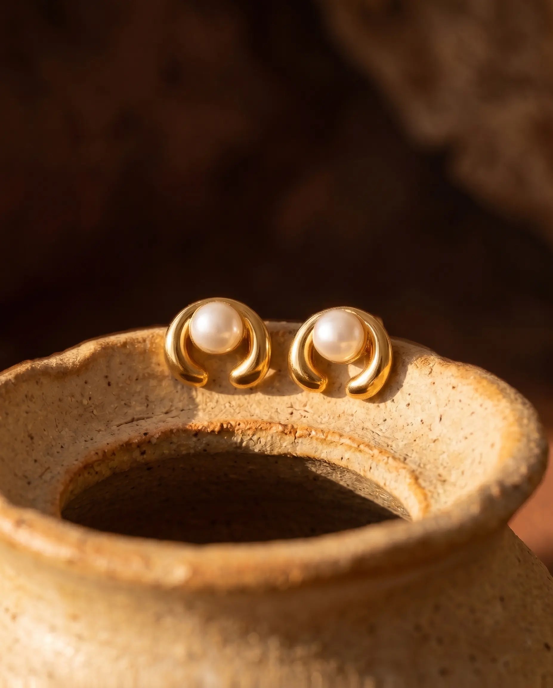 close-up-of-celine-pearl-studs-displayed-on-minimalist-ceramic-pot-highlighting-gold-finish-and-design-detail