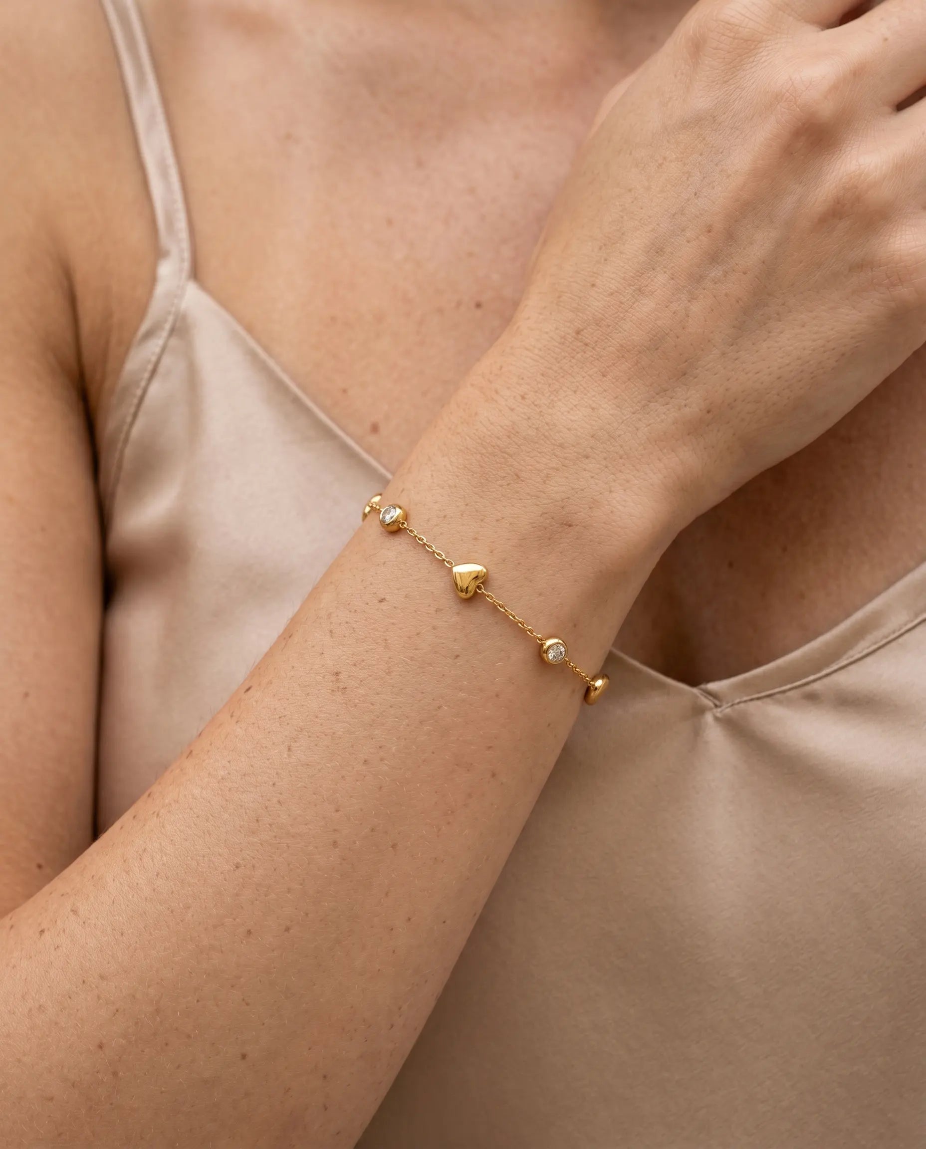 close-up-of-hartel-heart-bracelet-worn-by-model-to-emphasize-delicate-chain-and-stationed-charms