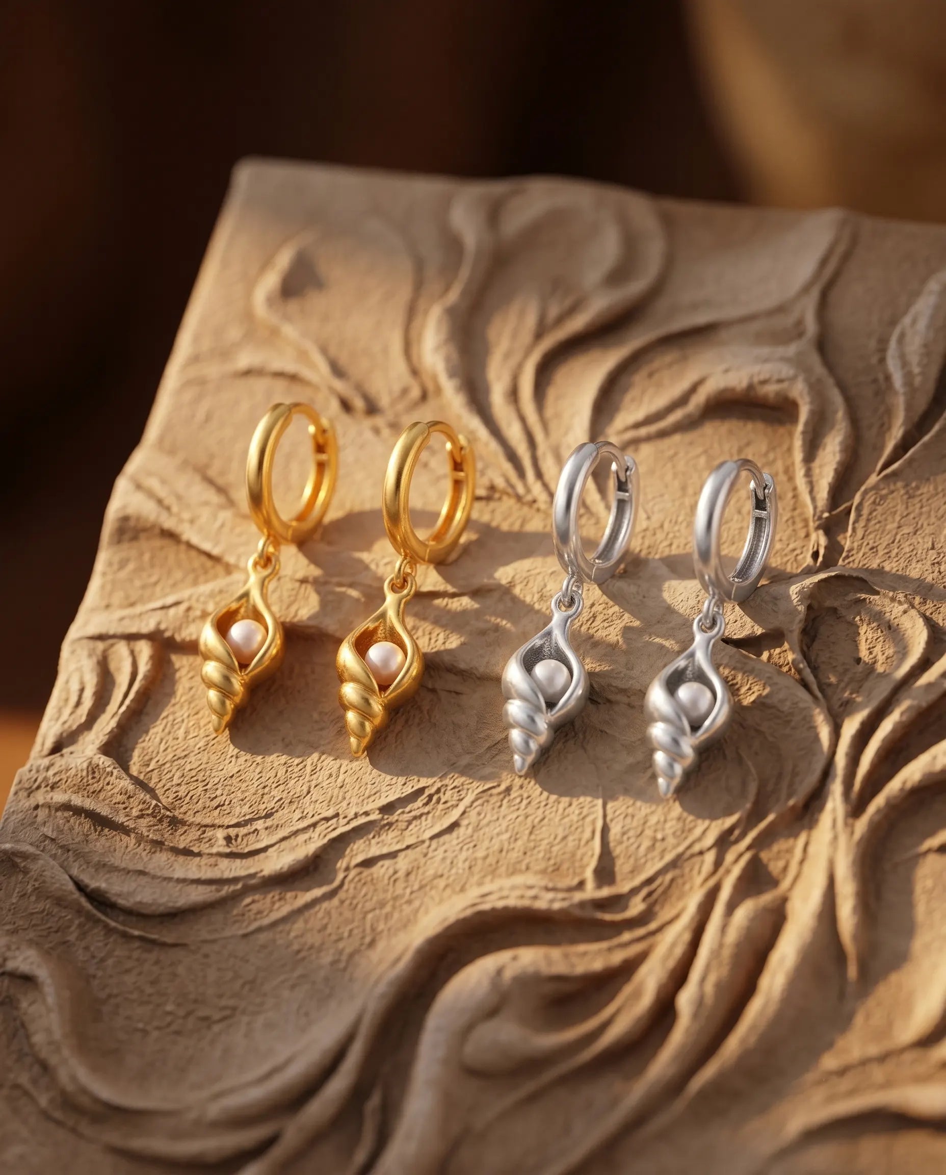 close-up-of-marea-pearl-shell-drop-earrings-displayed-on-minimalist-dish-highlighting-the-fine-metal-detailing