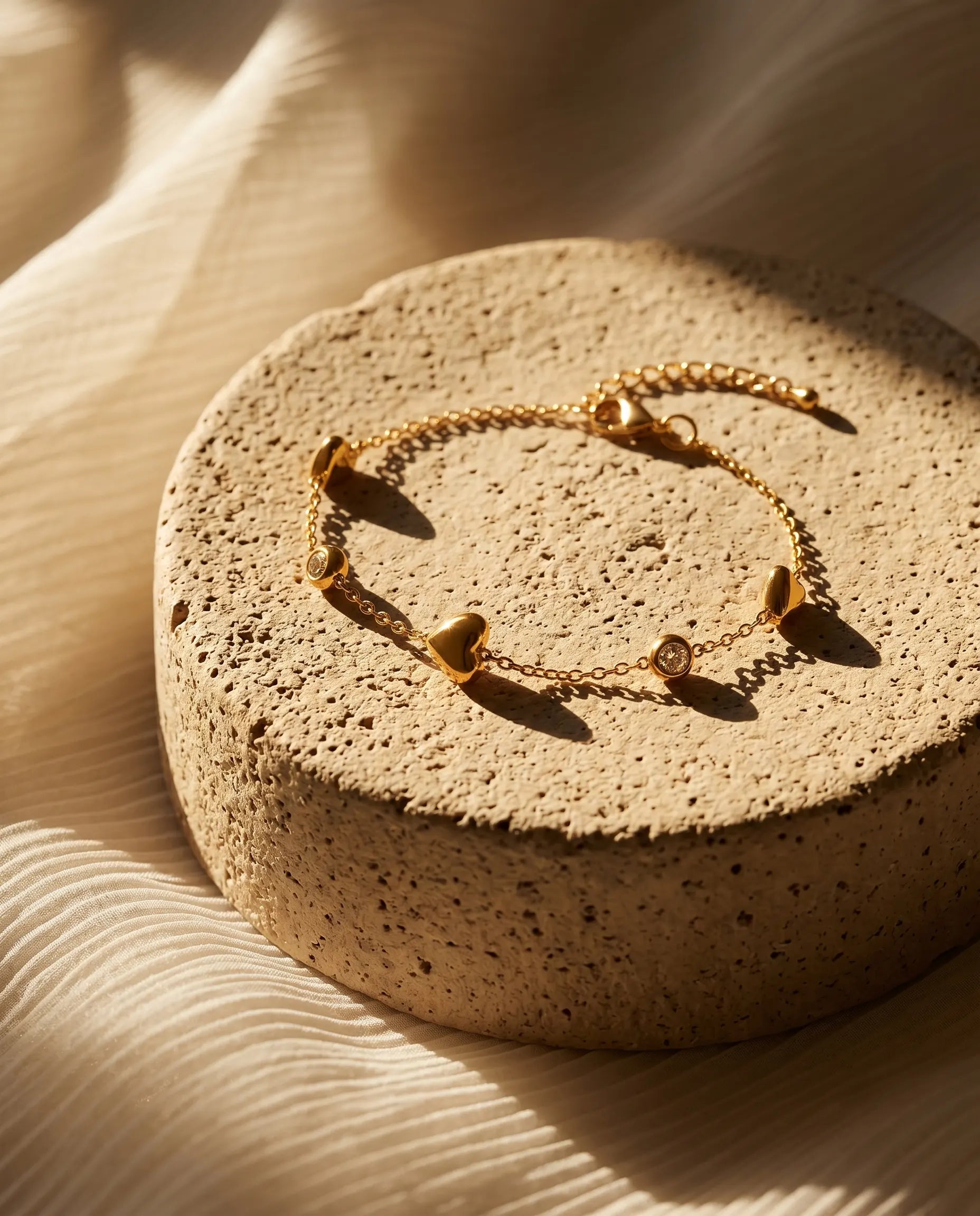 hartel-heart-station-bracelet-on-minimalist-crystal-display-highlighting-gold-finish-and-design-detail