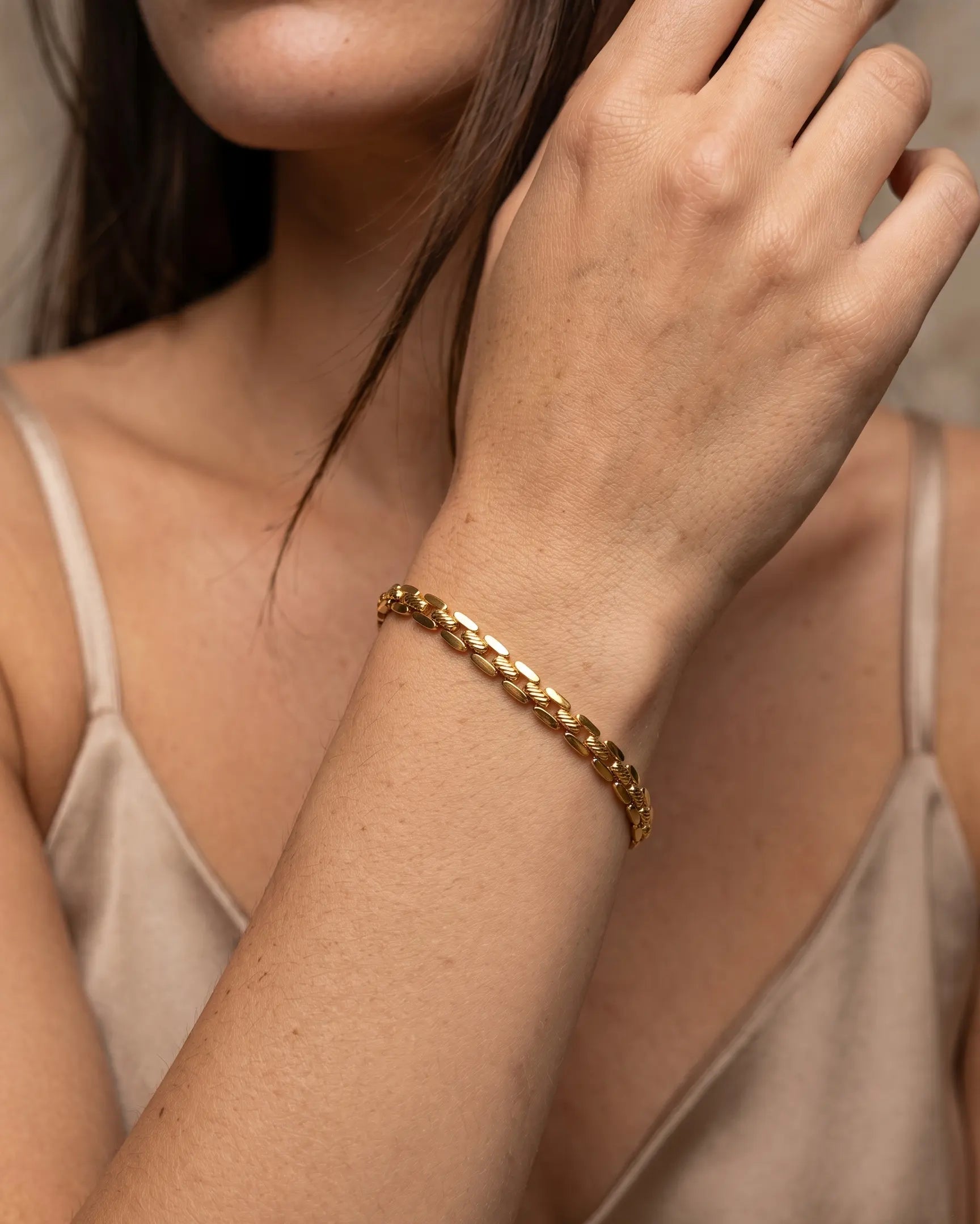 model-wearing-gold-caelina-curb-chain-bracelet, elegant-statement-jewelry-lifestyle, professional-women-jewelry-style, chic-minimalist-accessories-for-daily-wear, luxury-lifestyle-brand-photography, premium-jewelry-model-shot