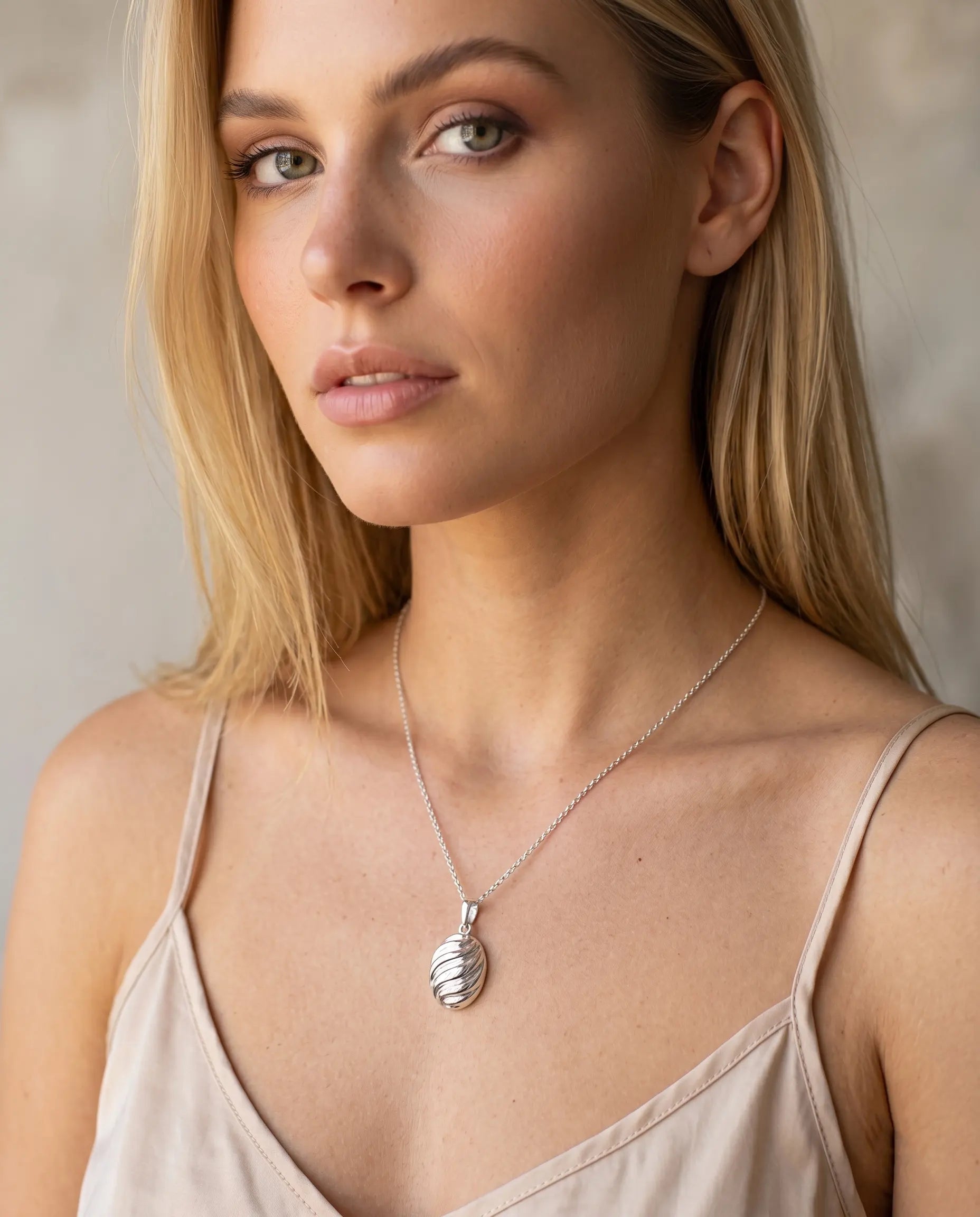 model-wearing-gold-coralia-shell-necklace, elegant-summer-statement-jewelry-lifestyle, professional-women-vacation-style, chic-minimalist-accessories-for-beachwear, luxury-lifestyle-brand-photography, premium-shell-pendant-model-shot
