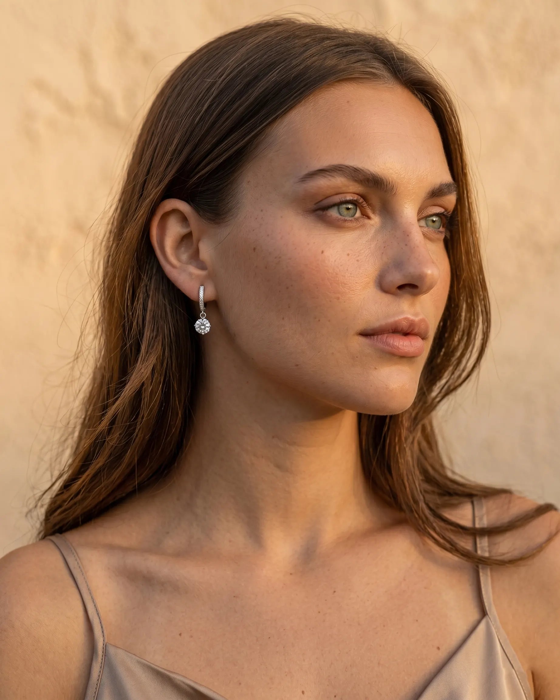 model-wearing-gold-dafne-drop-huggie-earrings-lifestyle, elegant-modern-feminine-jewelry-on-ear, professional-women-luxury-accessories, chic-solitaire-gold-styling, luxury-lifestyle-brand-model