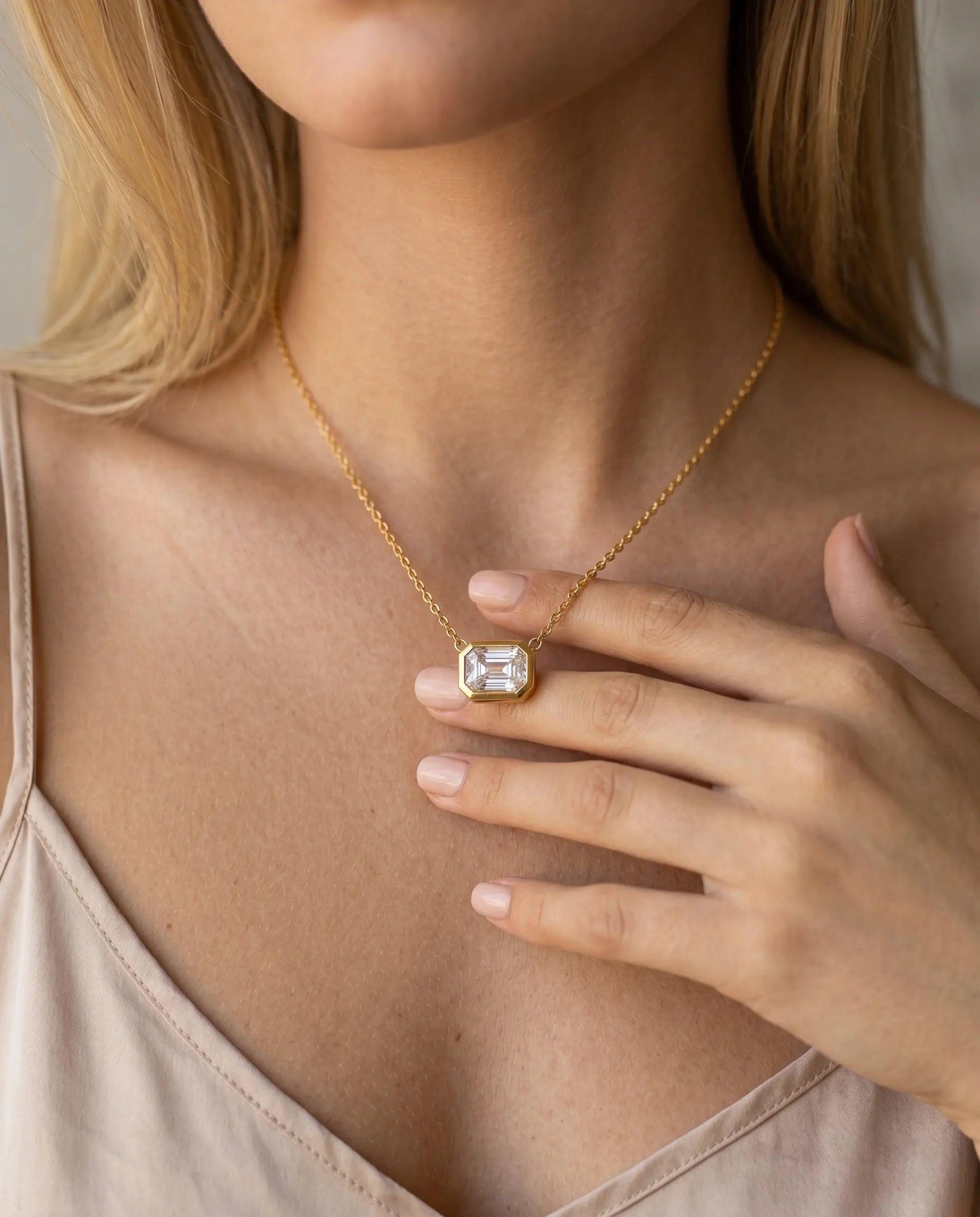 model-wearing-gold-quennie-emerald-cut-necklace-lifestyle, elegant-modern-feminine-jewelry-on-neck, professional-women-luxury-accessories, chic-geometric-solitaire-styling, luxury-lifestyle-brand-model