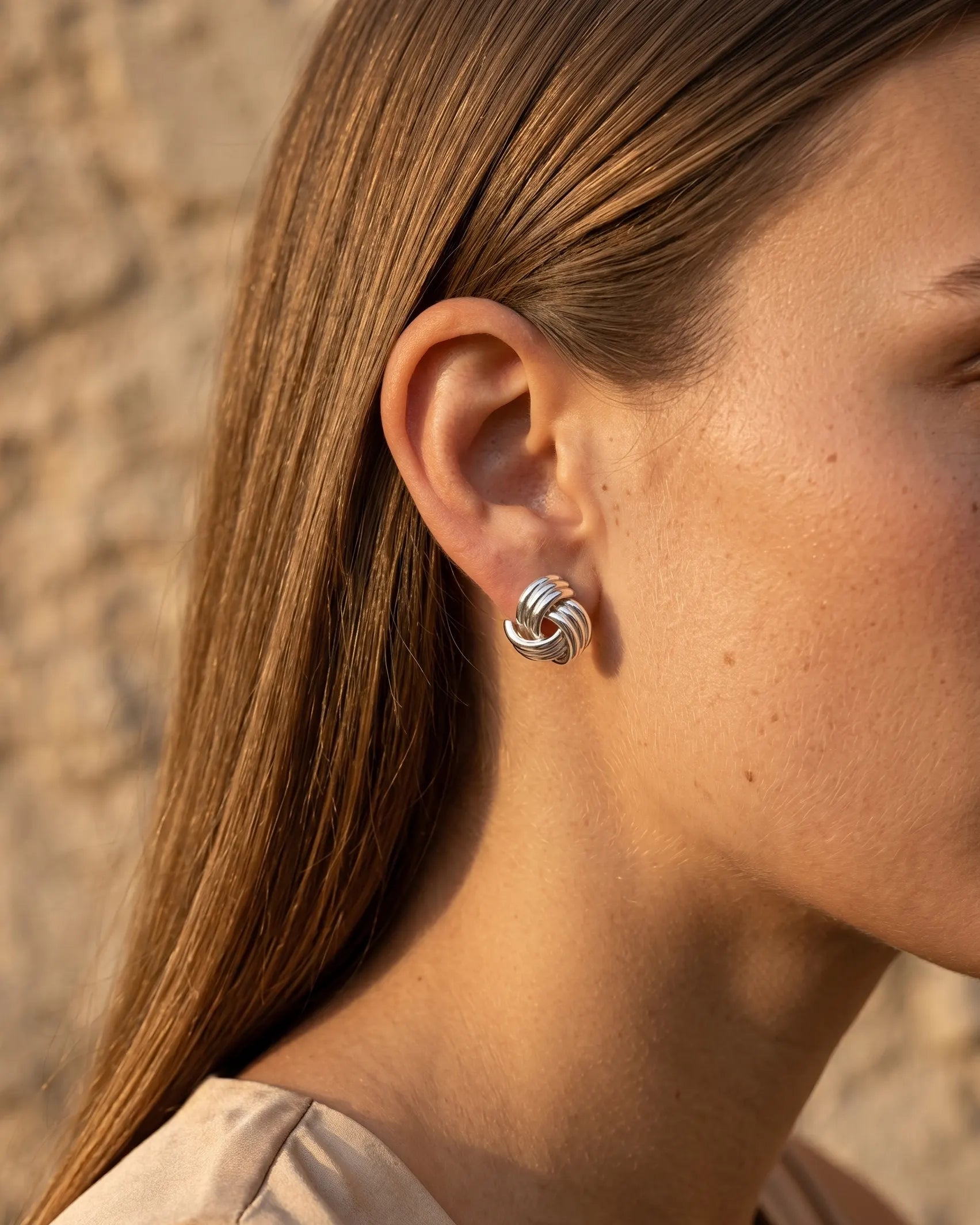 model-wearing-gold-samira-knot-earrings-lifestyle, elegant-modern-classic-jewelry-on-ear, professional-women-luxury-accessories, chic-gold-knot-stud-styling, luxury-lifestyle-brand-model