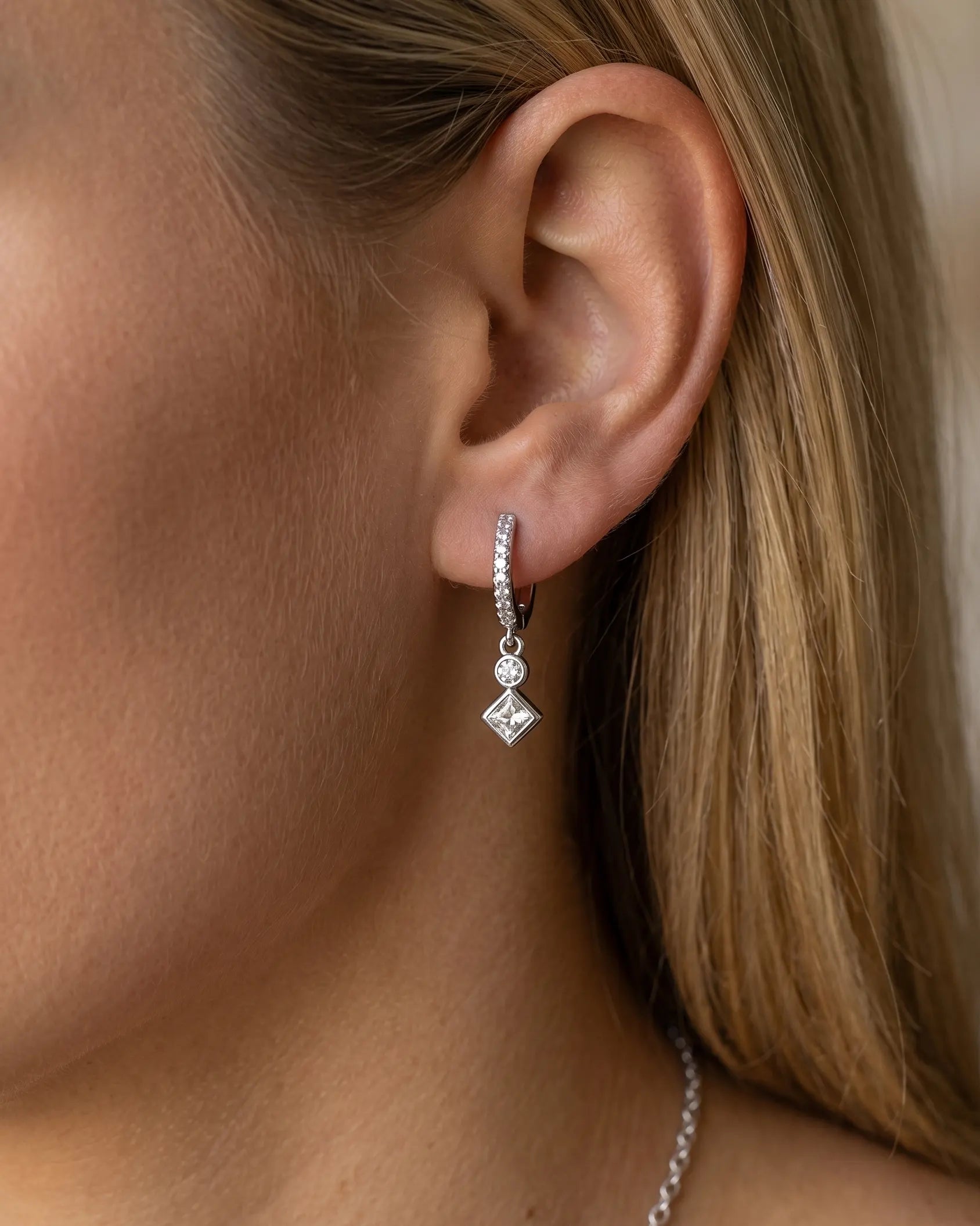 model-wearing-silver-mercedes-star-hoop-earrings-lifestyle, elegant-modern-feminine-jewelry-on-ear, professional-women-luxury-accessories, chic-celestial-silver-styling, luxury-lifestyle-brand-model