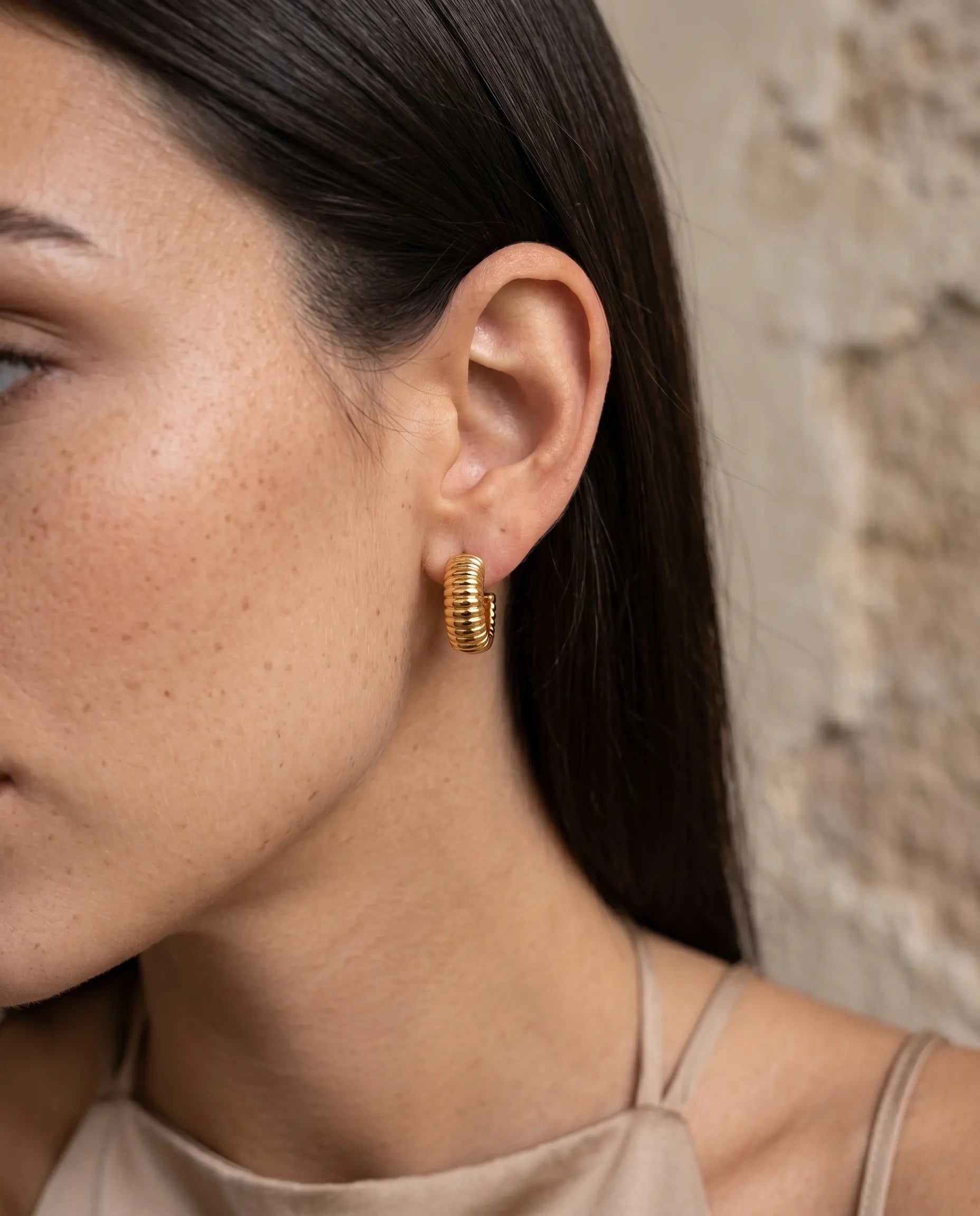 model-wearing-the-glam-ribbed-huggie-hoops-showcasing-bold-sculptural-design-and-perfect-fit-minimalist-styling