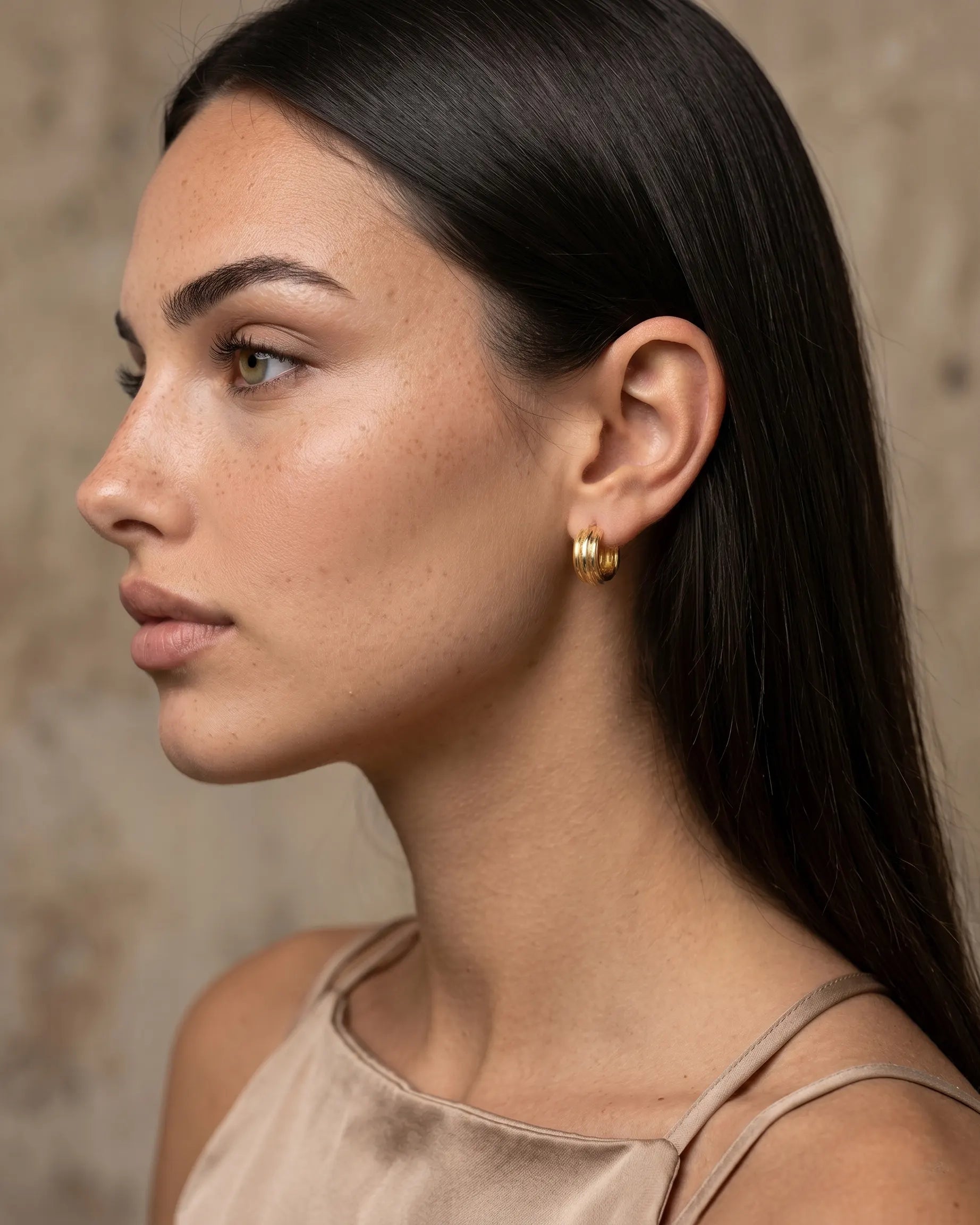 model-wearing-the-olive-textured-huggie-hoops-showcasing-minimalist-ear-stacking-style