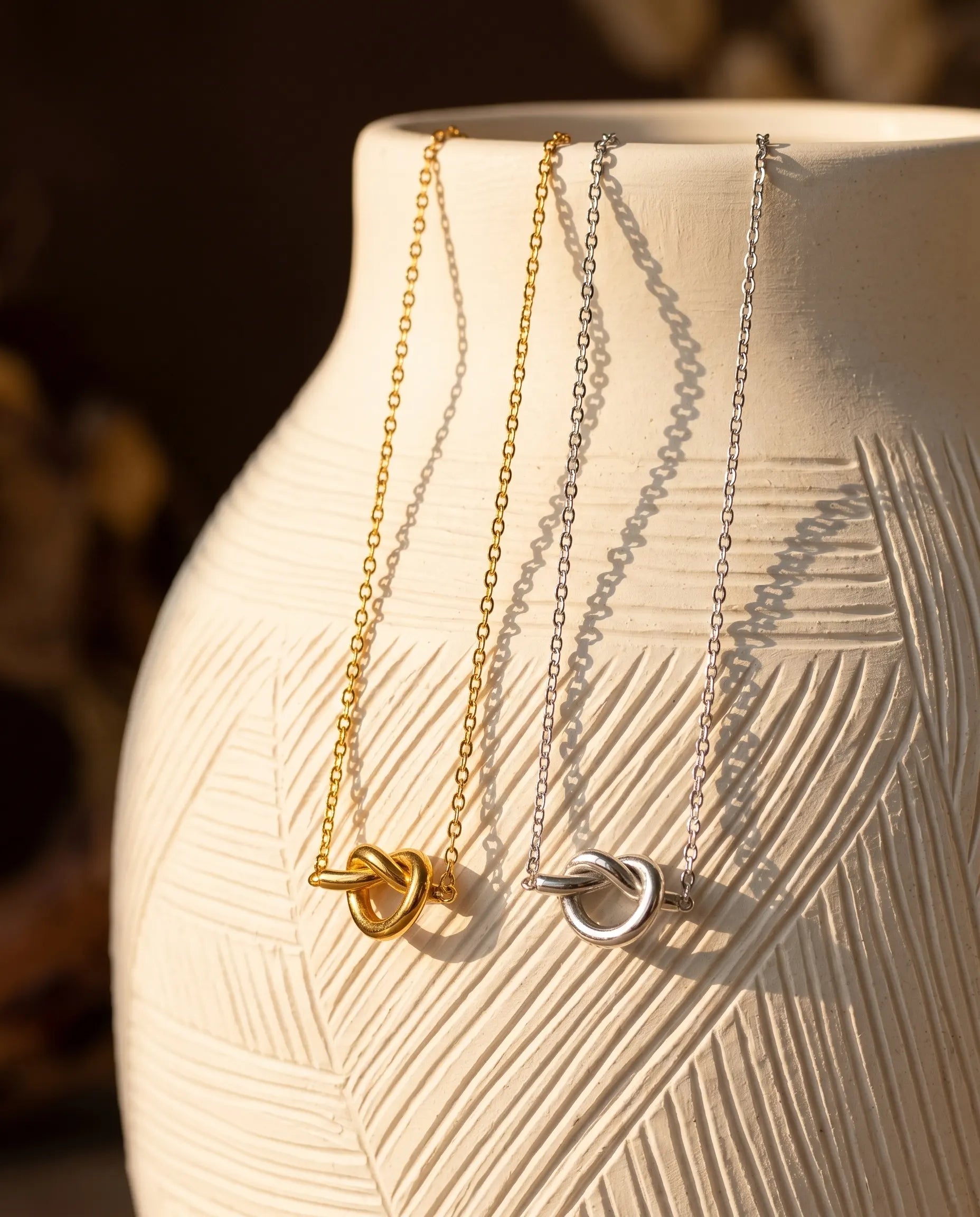 nerissa-knot-necklace-displayed-on-natural-stone-artistic-jewelry-photography-for-luxury-gifting-inspiration