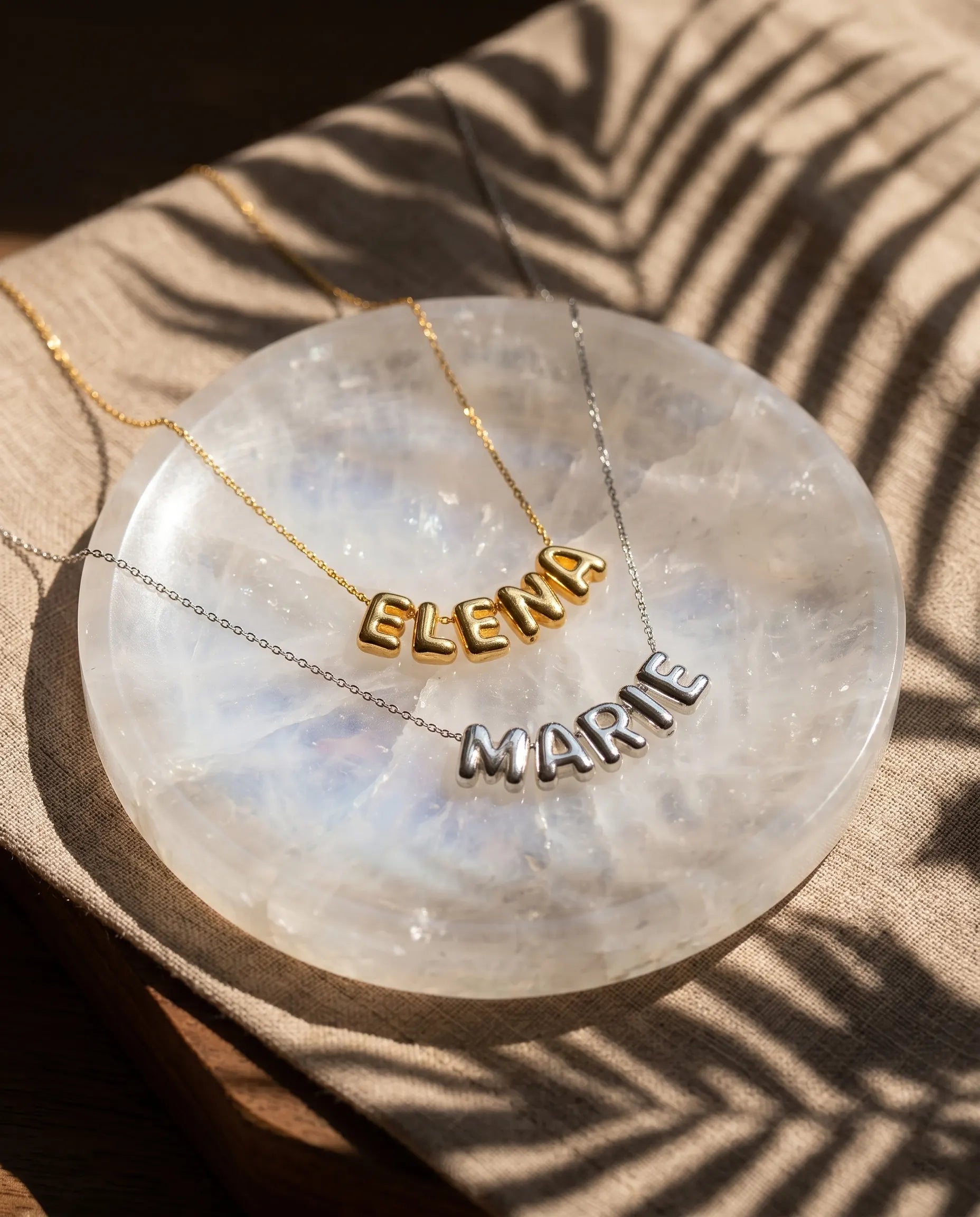 poppy-custom-name-necklaces-displayed-on-agate-slice-highlighting-personalized-script-and-stainless-steel-quality
