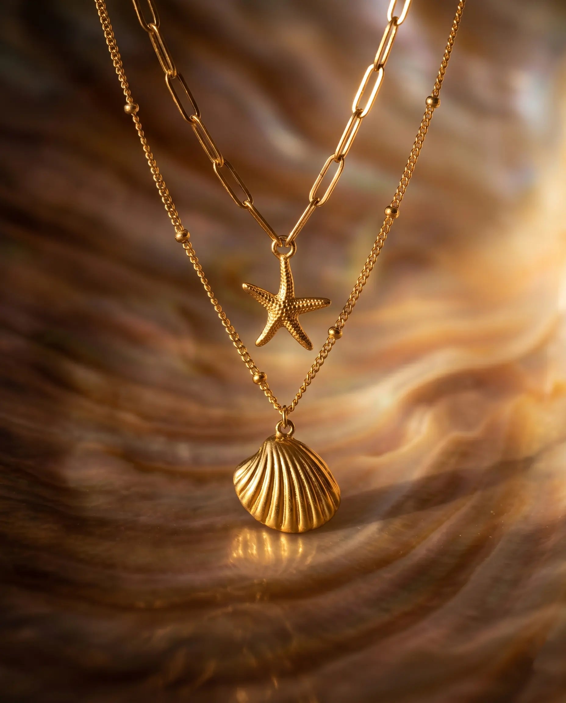 sunae-layered-gold-necklace-featuring-shell-and-starburst-charms-waterproof-stainless-steel-minimalist-coastal-jewelry-by-senya