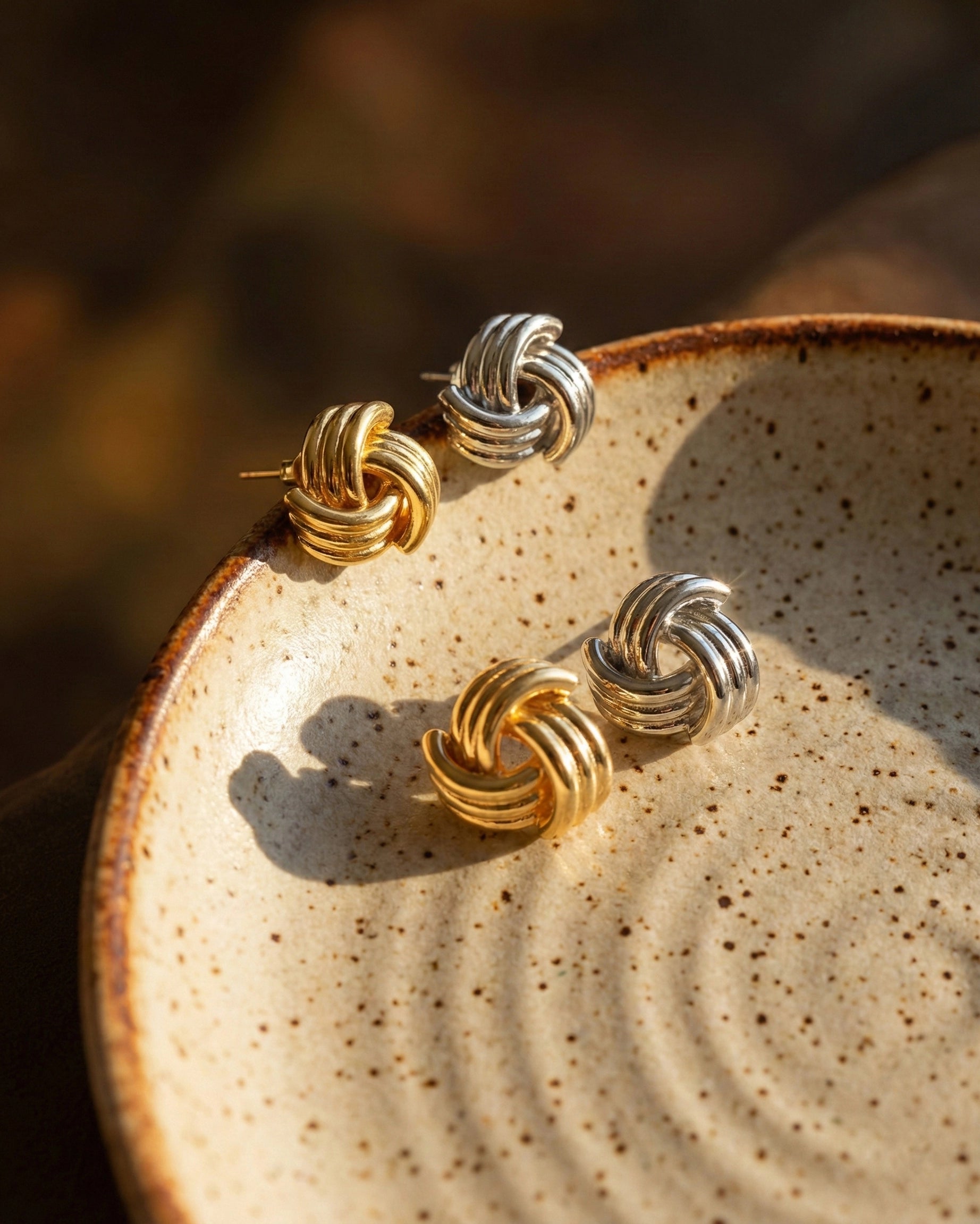 timeless-knot-aesthetic-stud-earrings-modern, 18k-gold-pvd-finish-detail-samira-earrings, gift-ideas-for-women-symbolic-jewelry, luxury-boutique-jewelry-netherlands, artistic-jewelry-flatlay-photography