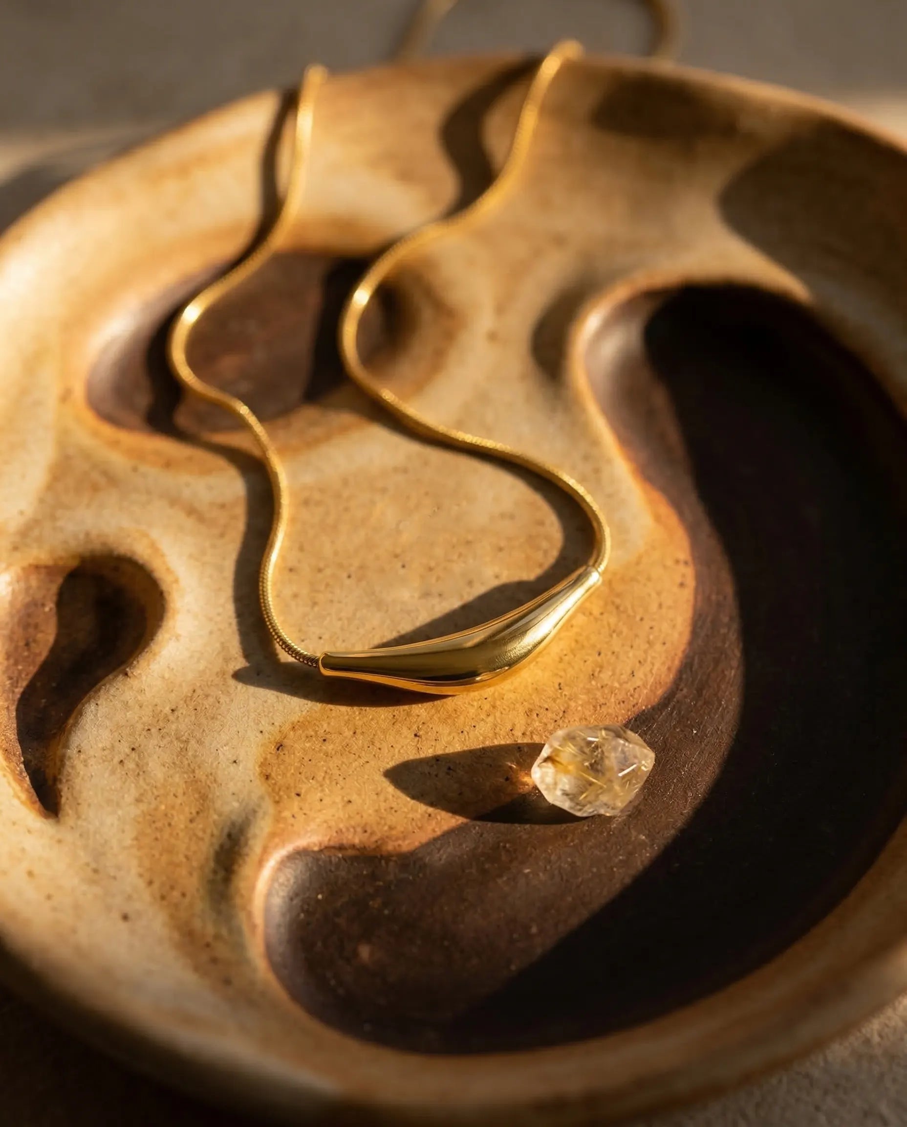 timeless-minimalist-aesthetic-prestige-gold-necklace, waterproof-finish-detail-sculptural-arc, gift-ideas-for-women-elegant-gold-jewelry, luxury-boutique-jewelry-netherlands, artistic-jewelry-flatlay-photography