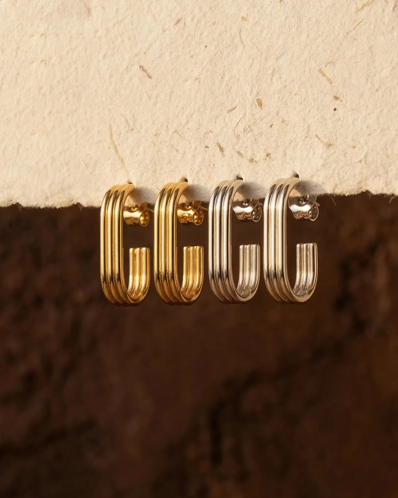 timeless-modern-aesthetic-ursula-ribbed-hoops-gold-silver, 18k-gold-pvd-finish-detail-structural-earrings, gift-ideas-for-women-bold-geometric-jewelry, luxury-boutique-jewelry-netherlands, artistic-jewelry-flatlay-photography